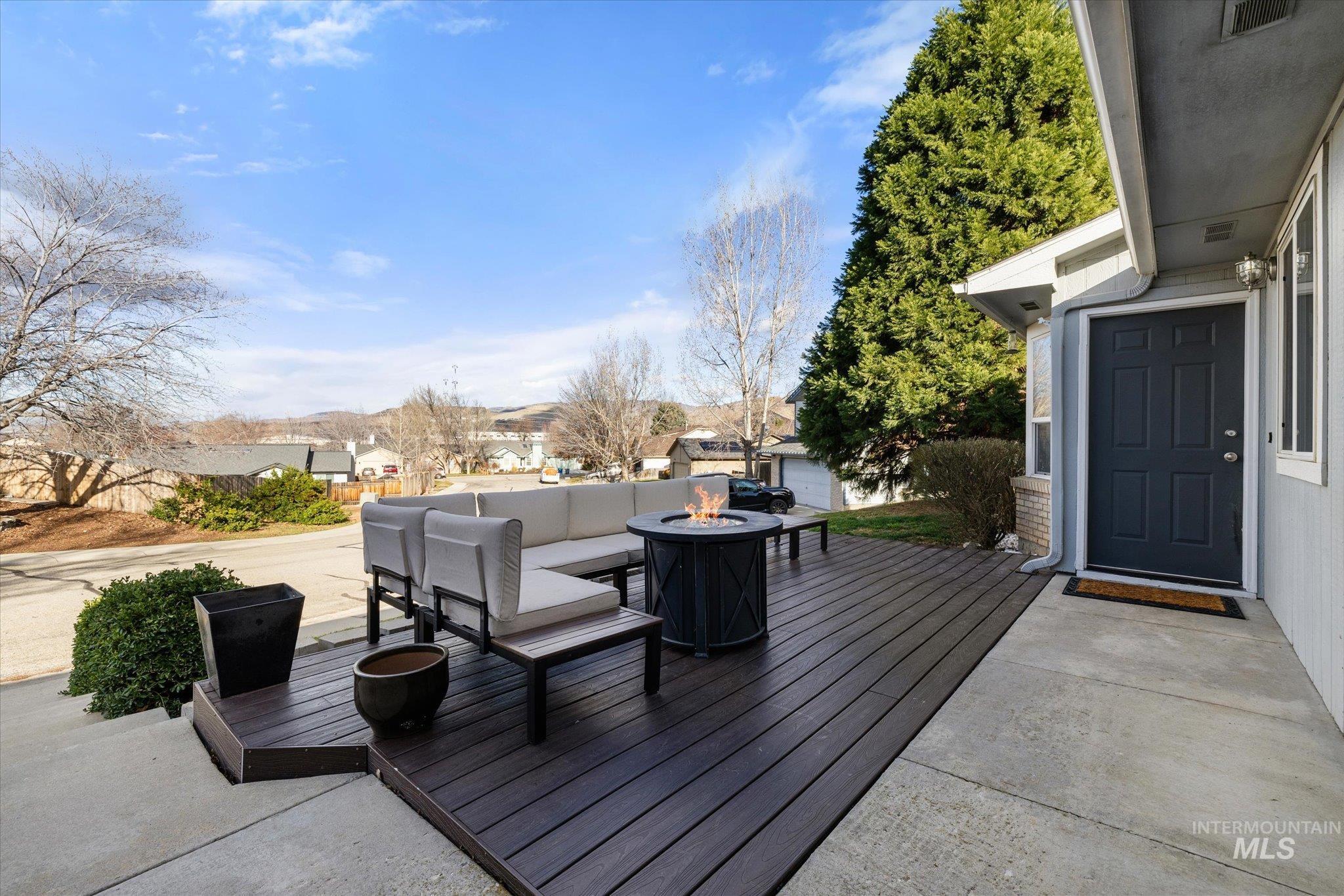Wooden deck featuring an outdoor living space with a fire pit and a residential view