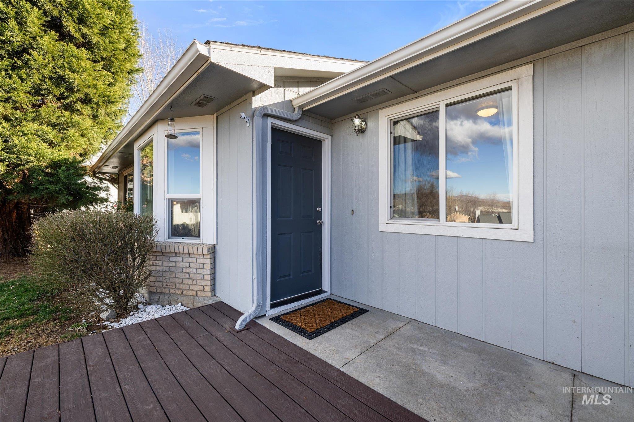 Entrance to property with a deck and brick siding