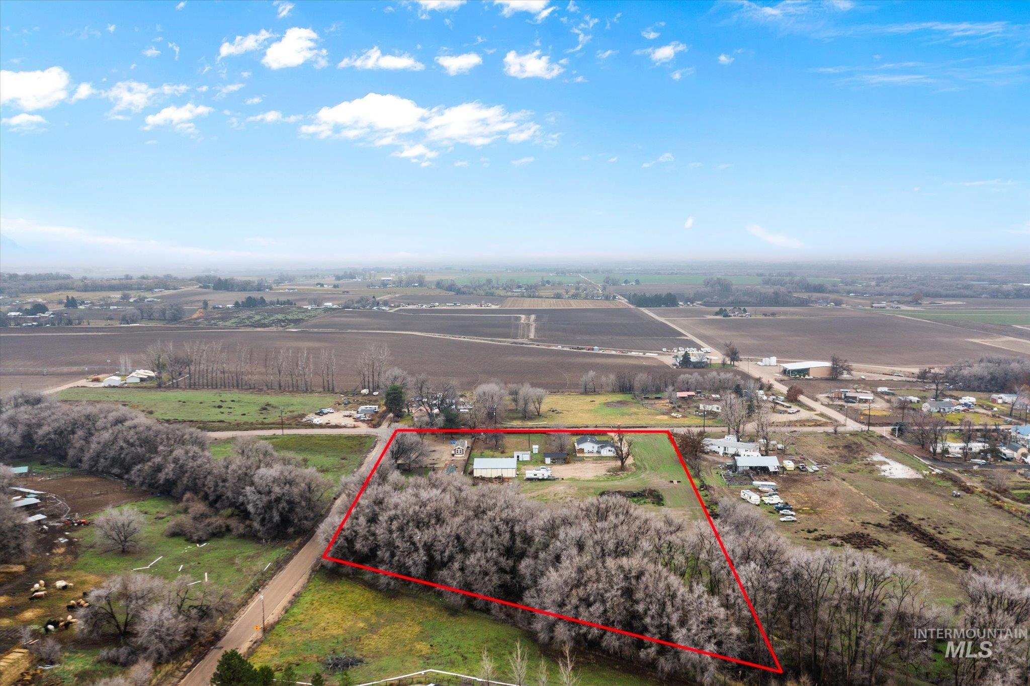 Aerial view of sparsely populated area featuring rows of crops and property boundaries highlighted