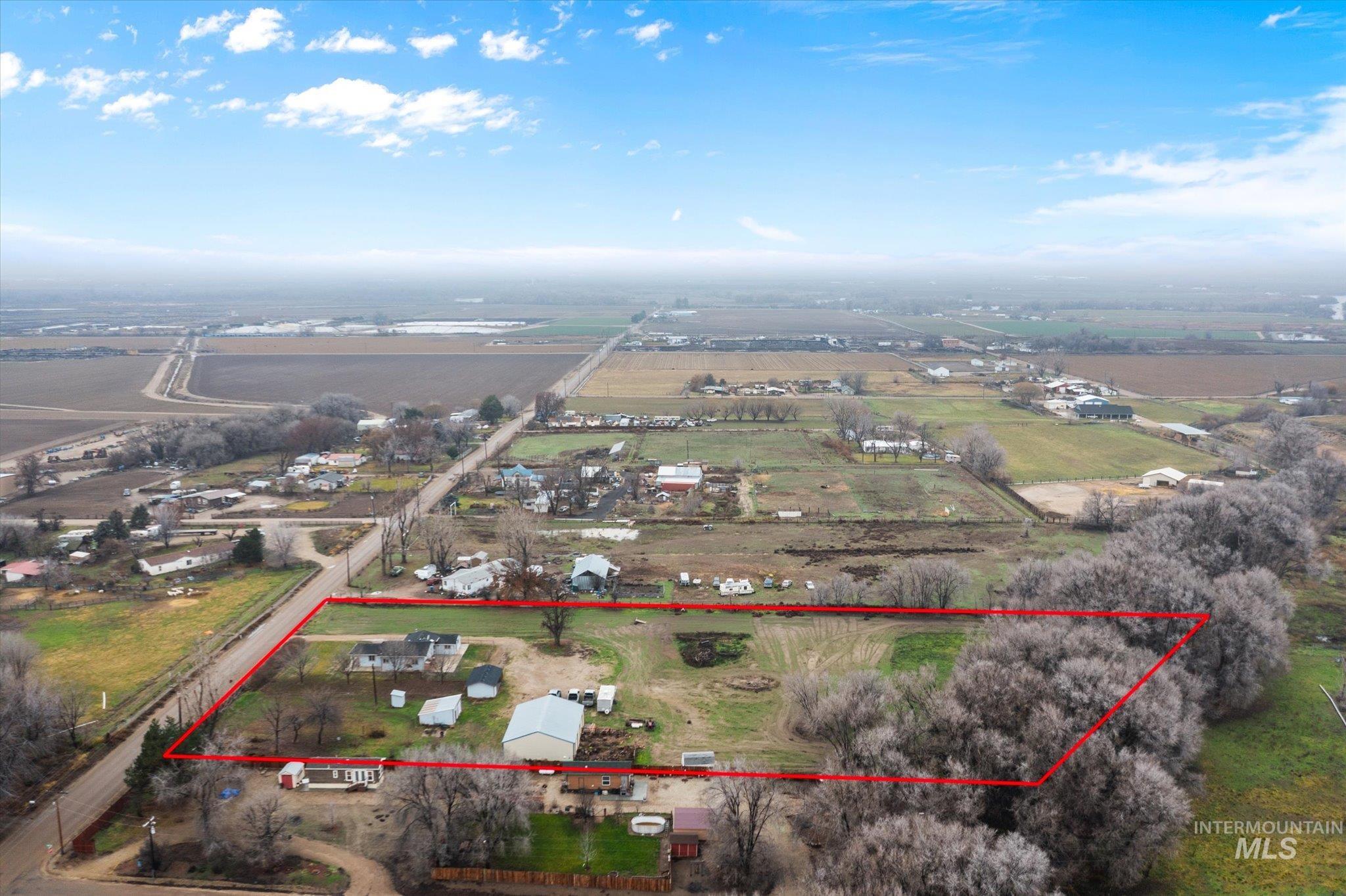 Aerial view of sparsely populated area featuring property parcel outlined