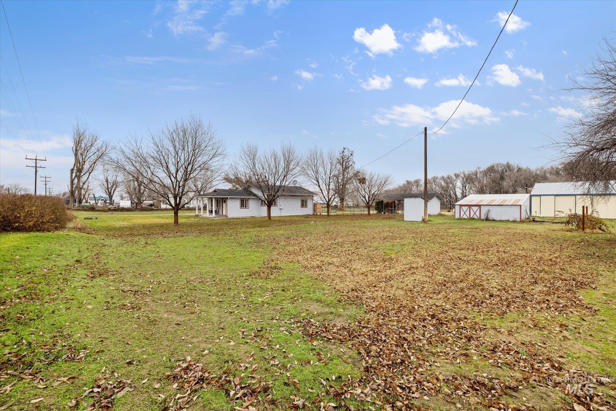 View of green lawn featuring an outbuilding