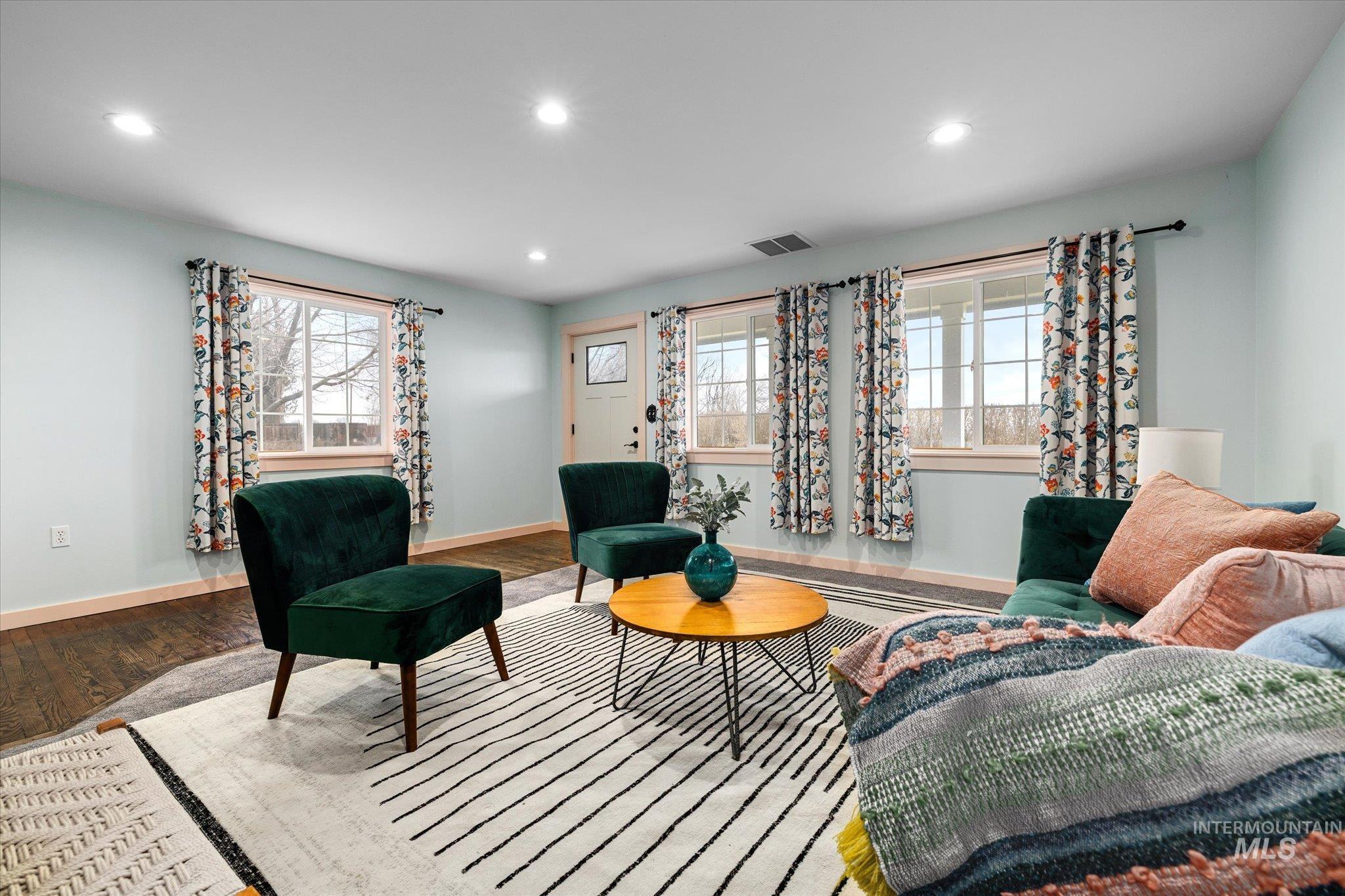 Living area with recessed lighting, wood-type flooring, and plenty of natural light