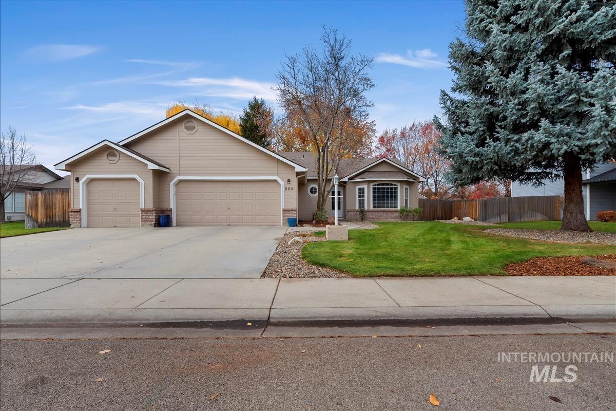 Ranch-style home with concrete driveway, an attached garage, and brick siding