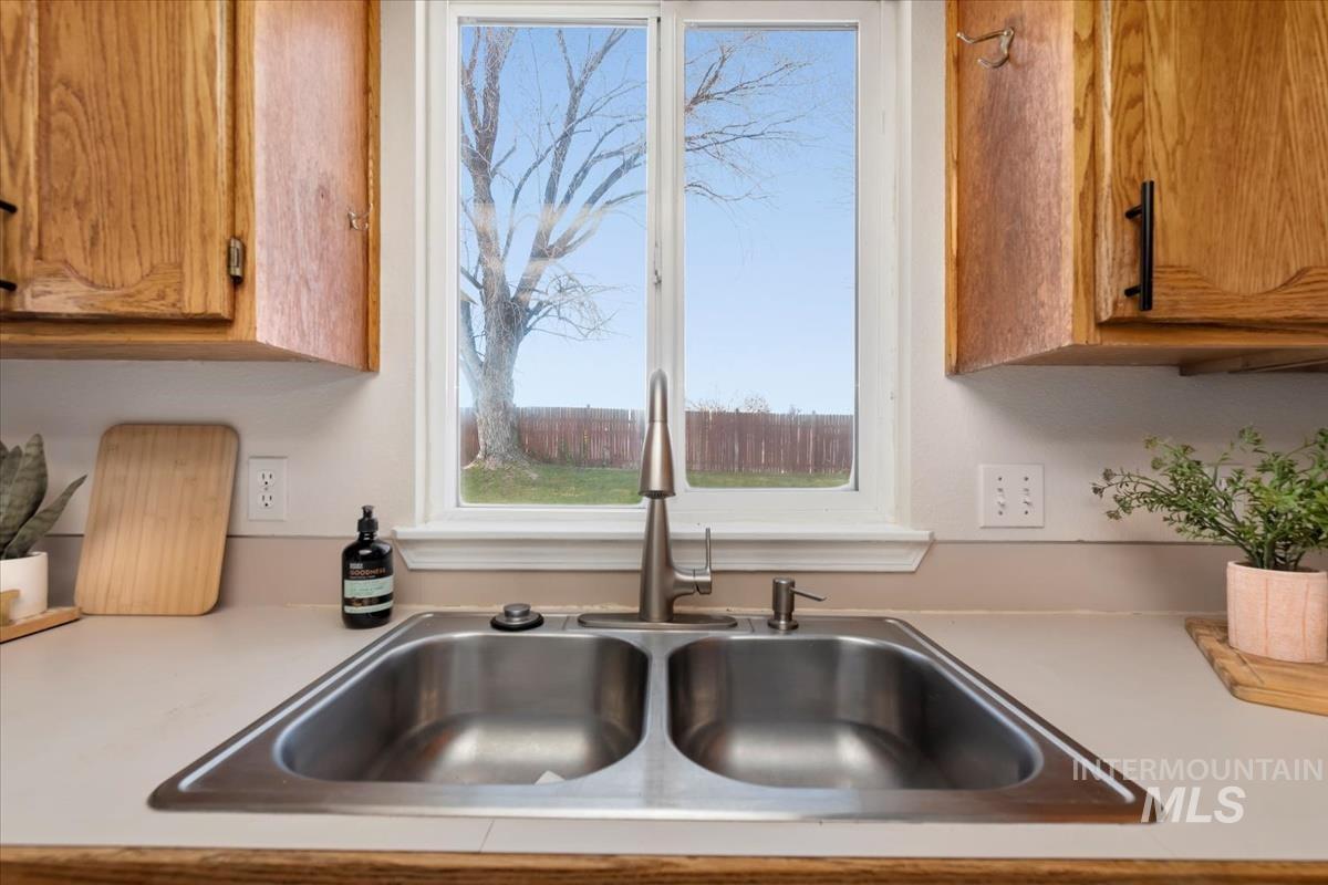 Kitchen view of brown cabinetry and light countertops