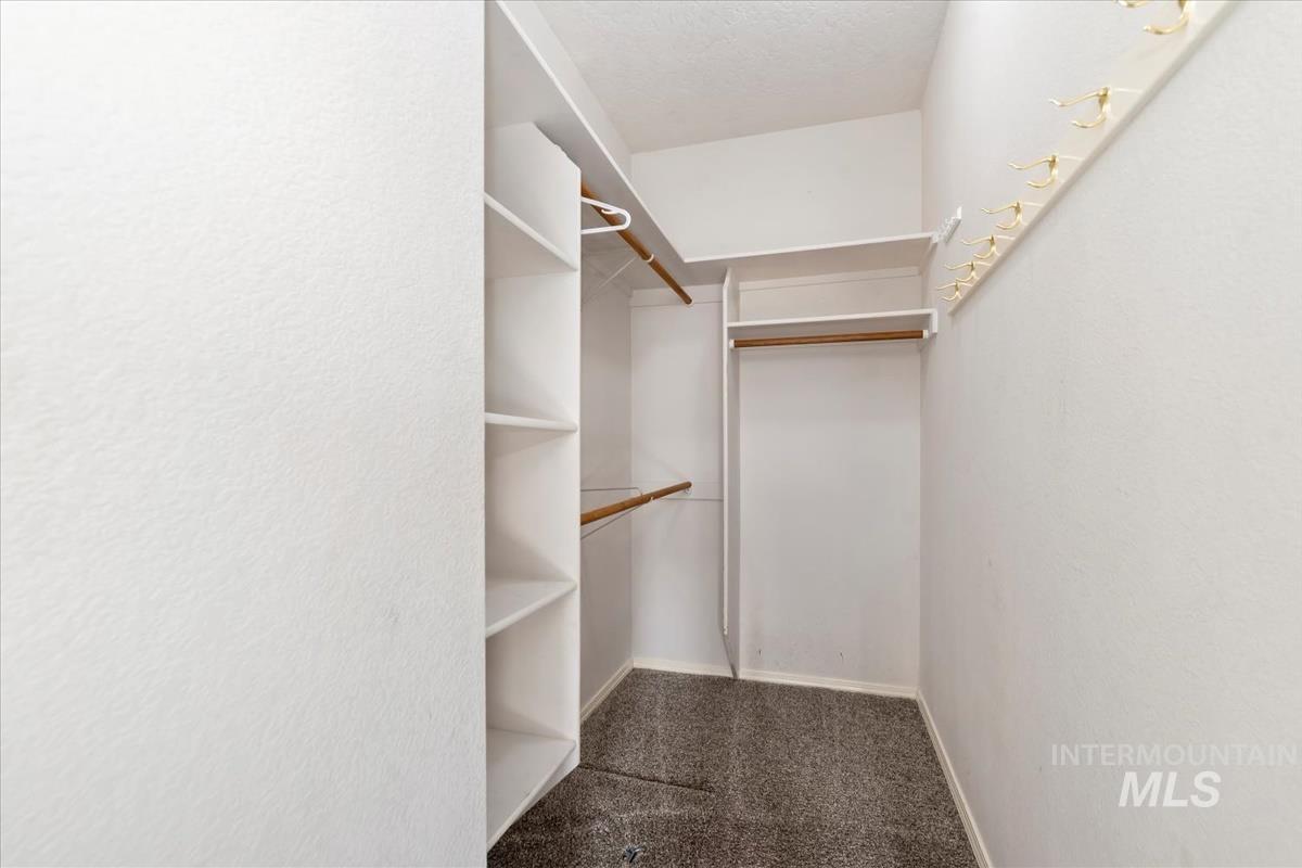 Walk in closet with dark carpet