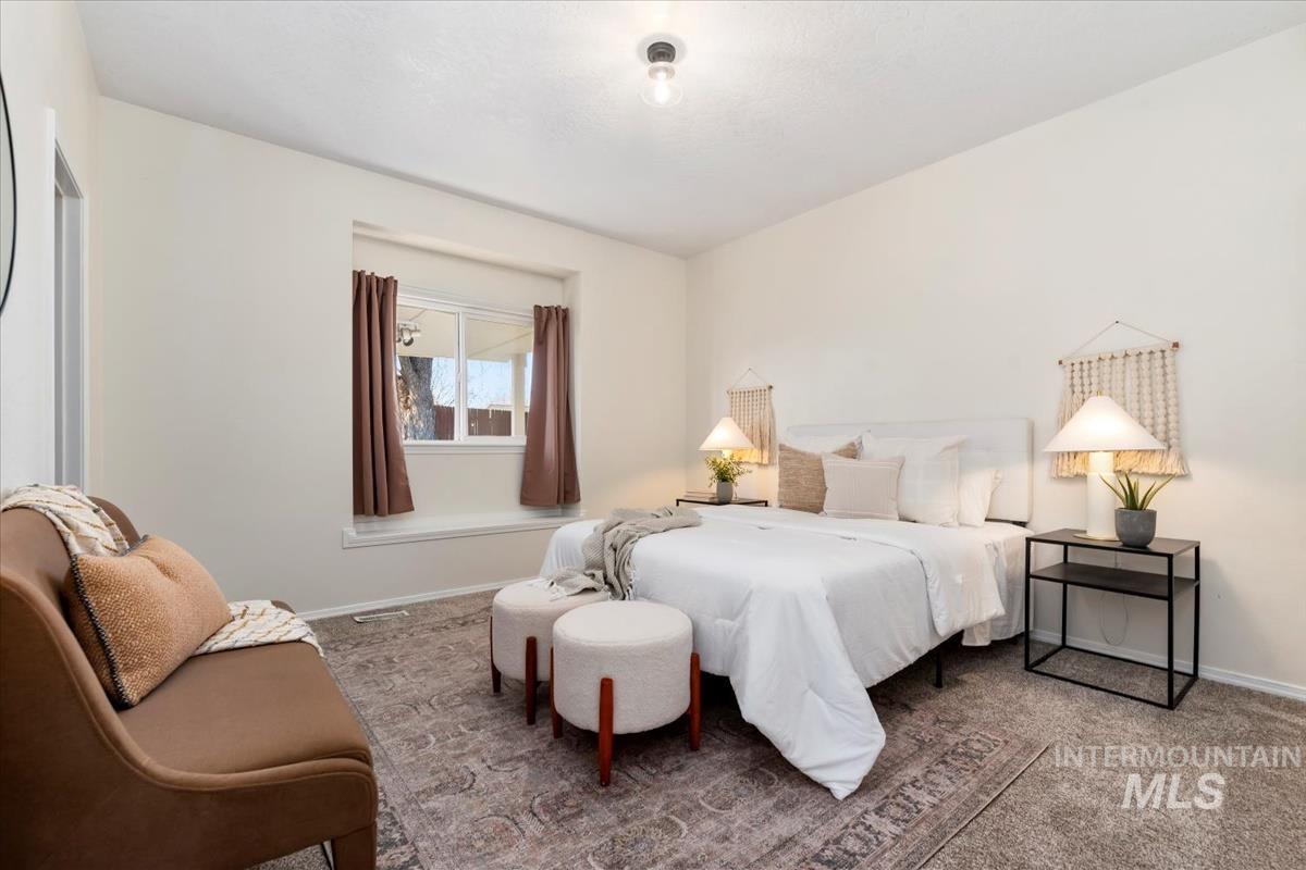 Bedroom featuring carpet flooring and baseboards
