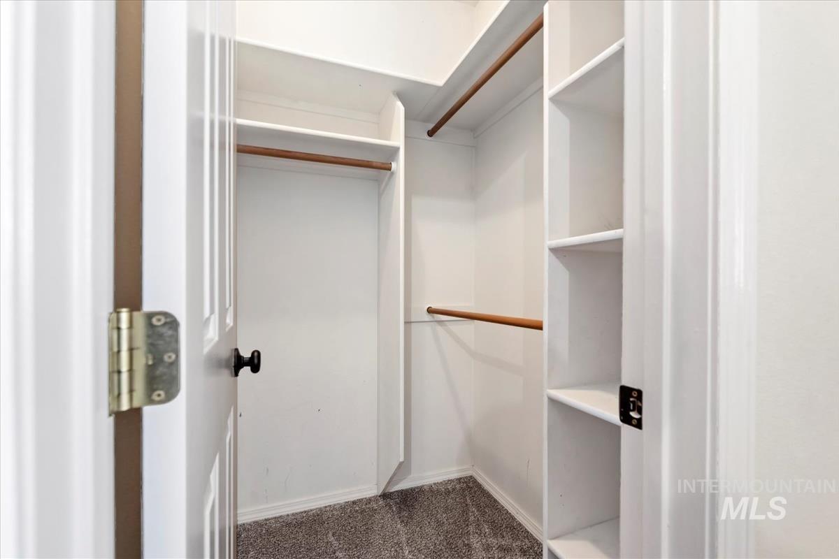 Walk in closet with dark carpet