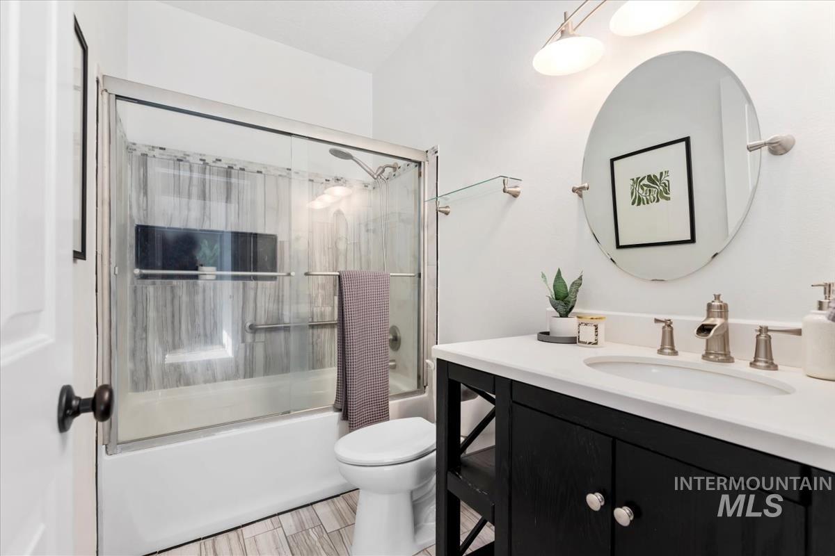 Full bath featuring vanity and enclosed tub / shower combo