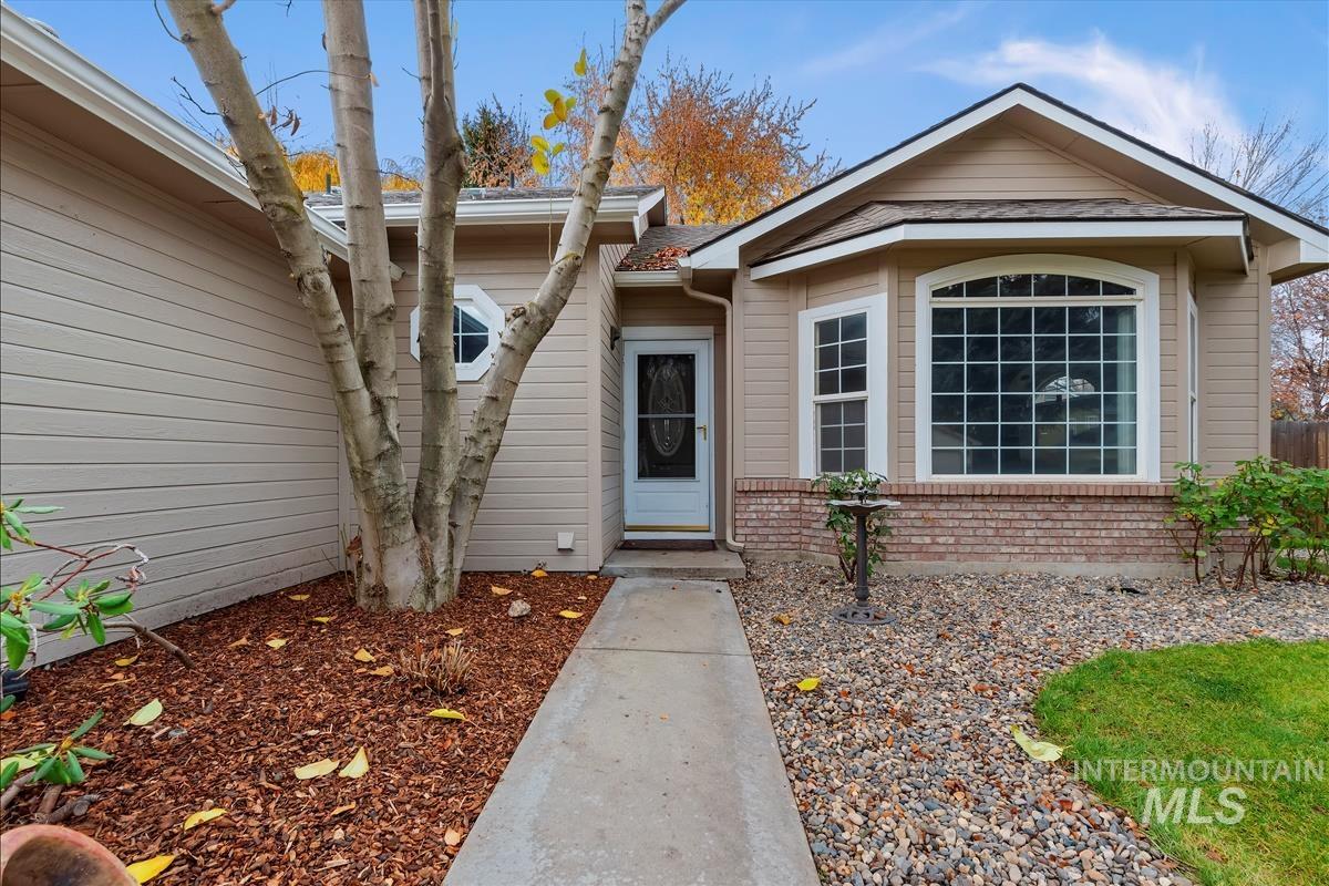 Property entrance featuring brick siding and roof with shingles