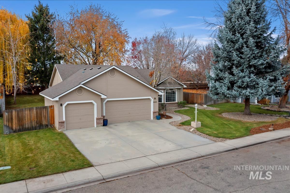 View of front of house with a garage, concrete driveway, roof with shingles, and brick siding