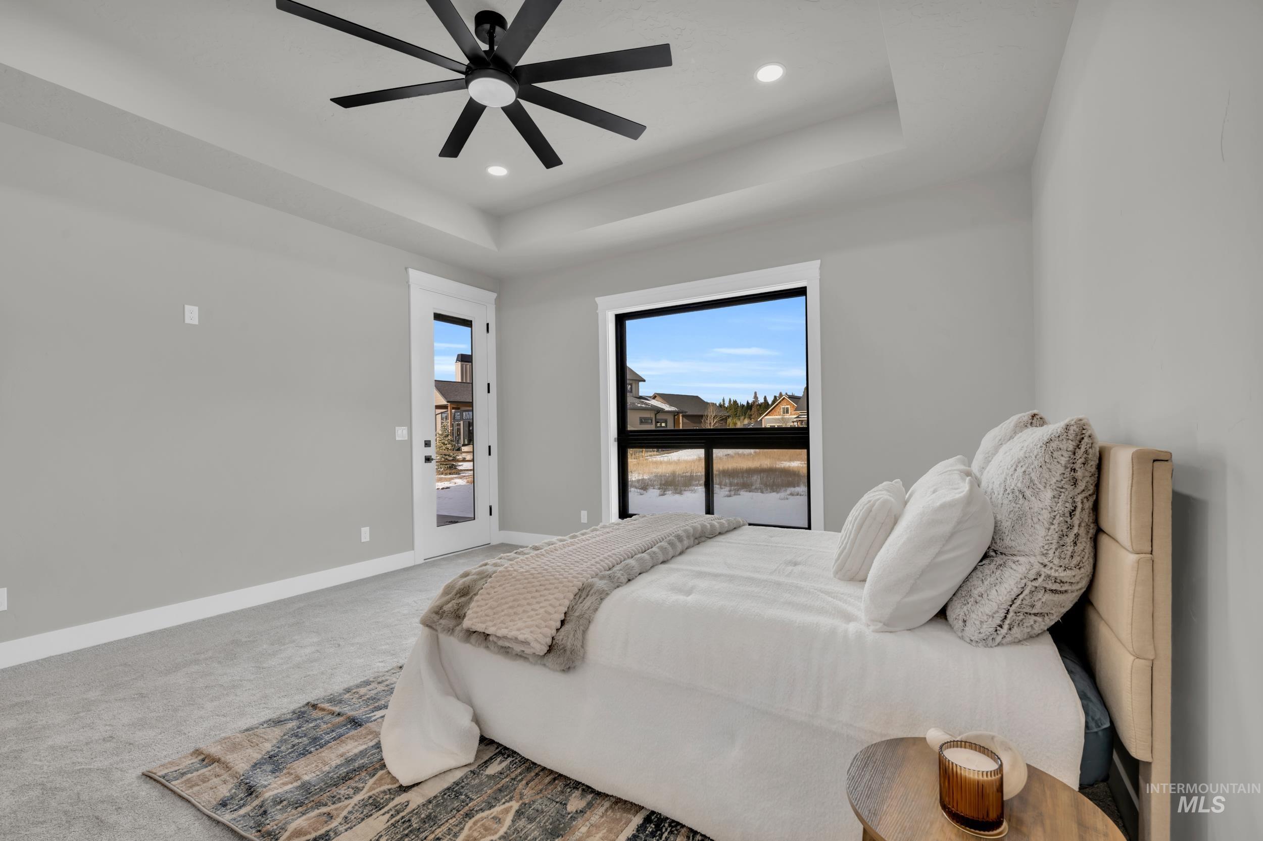Bedroom featuring a tray ceiling, access to outside, carpet flooring, ceiling fan, and recessed lighting