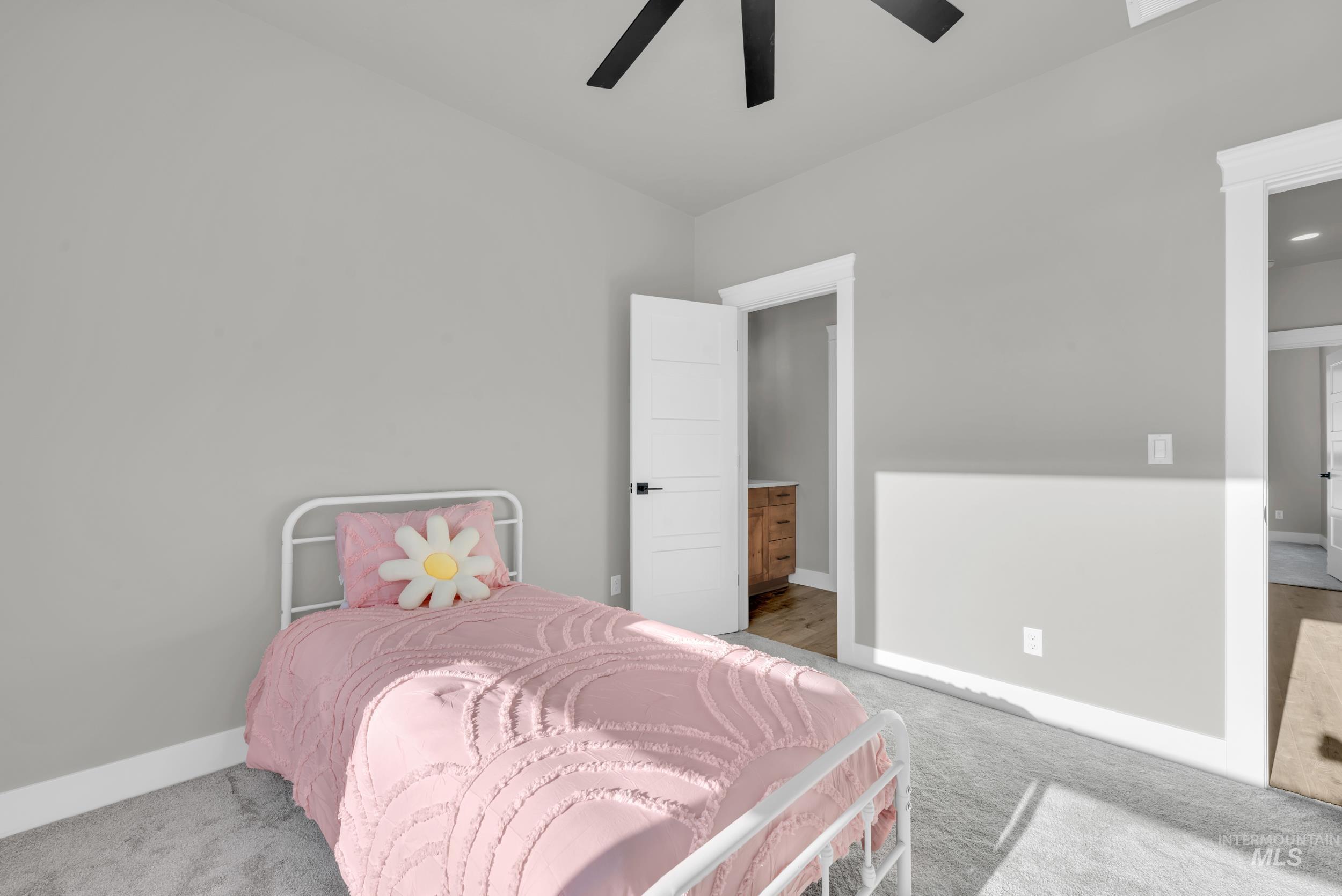 Bedroom featuring carpet flooring, a ceiling fan, and connected bathroom