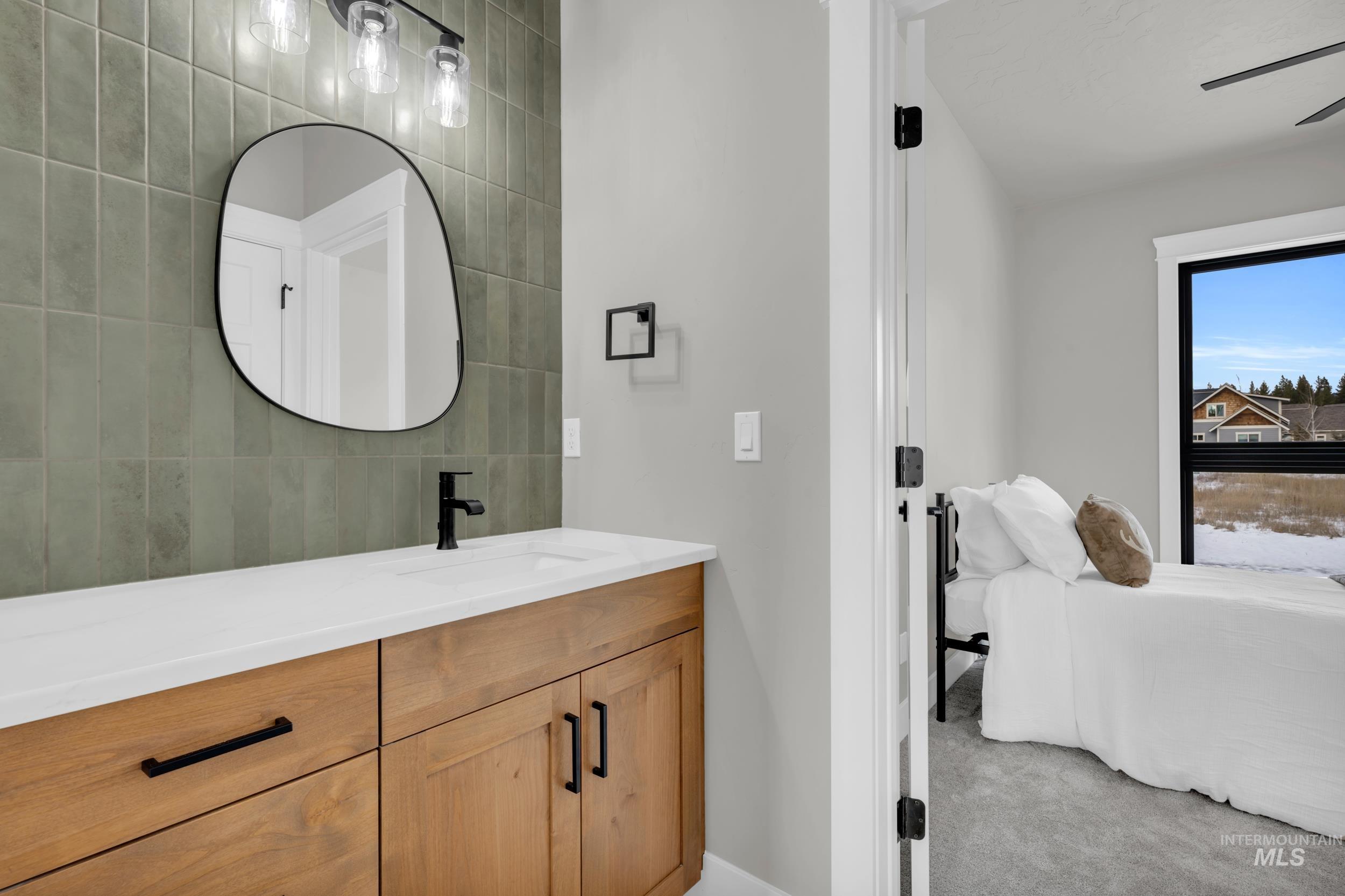 Ensuite bathroom with vanity and light carpet