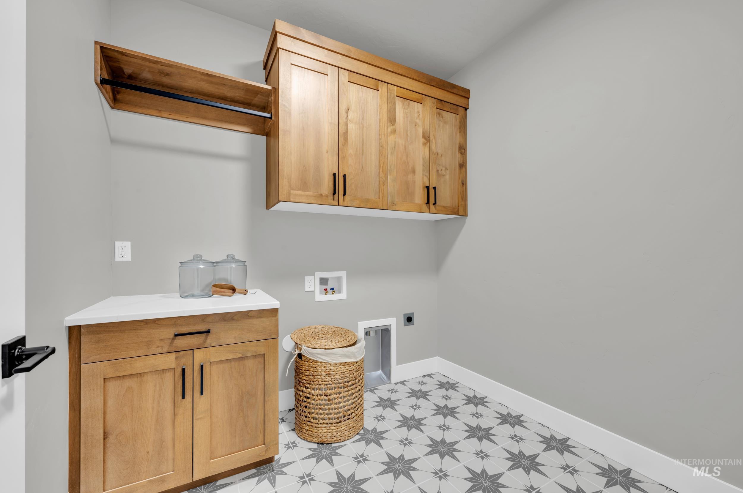 Laundry room with light floors, hookup for a washing machine, cabinet space, and hookup for an electric dryer