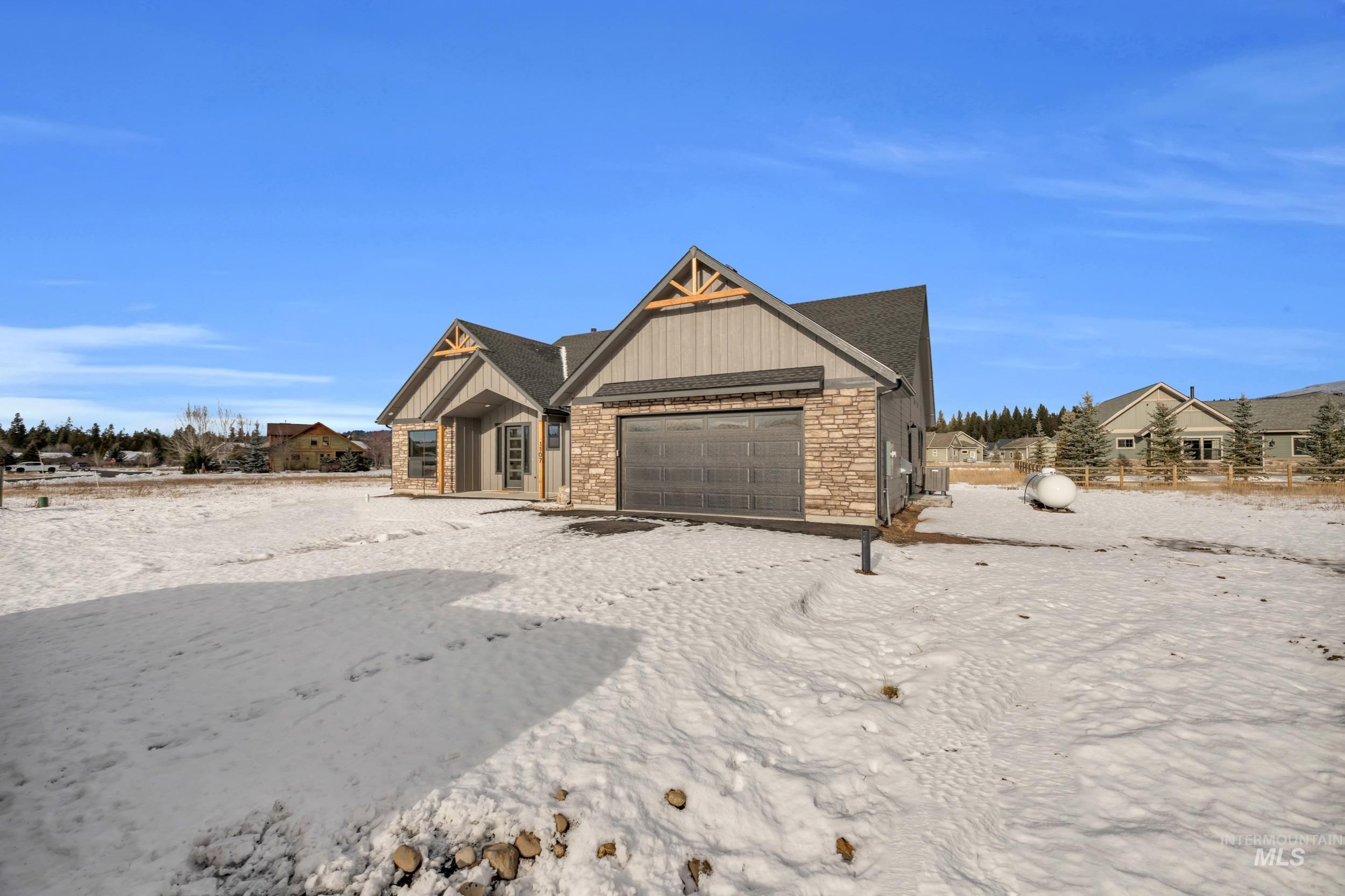 View of front of property featuring stone siding and an attached garage