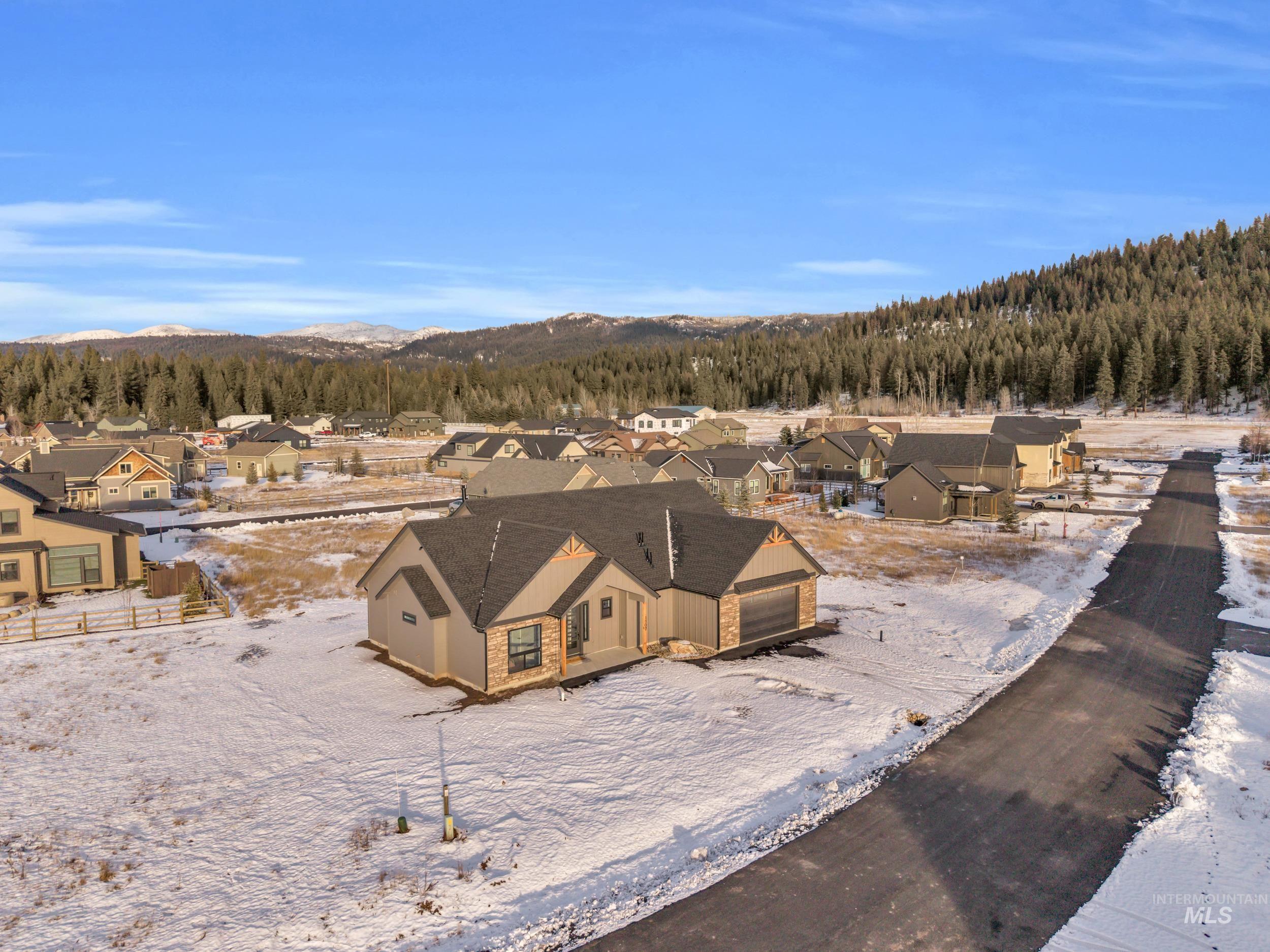 Snowy aerial view with a residential view and a view of trees
