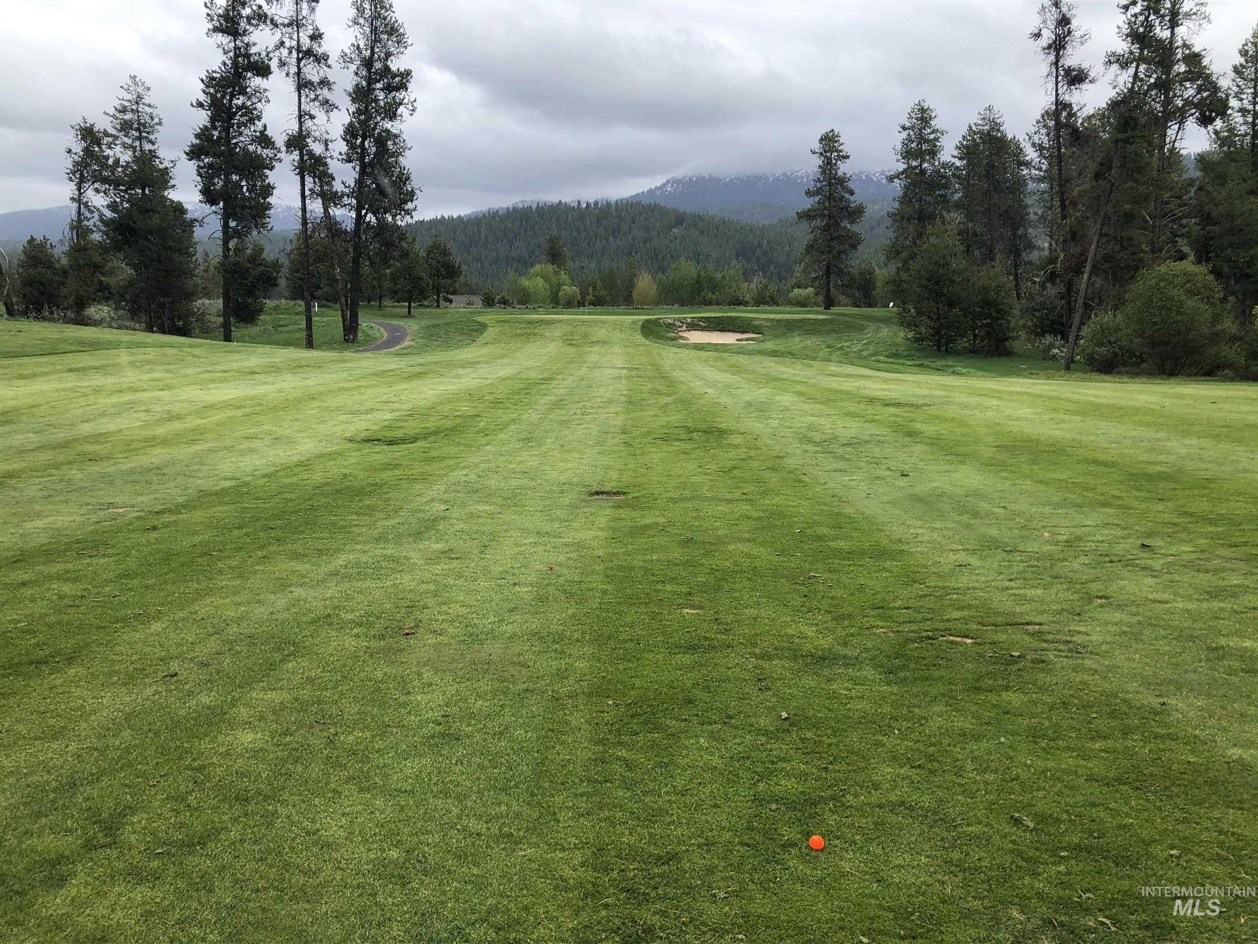 View of community featuring a yard and a wooded view