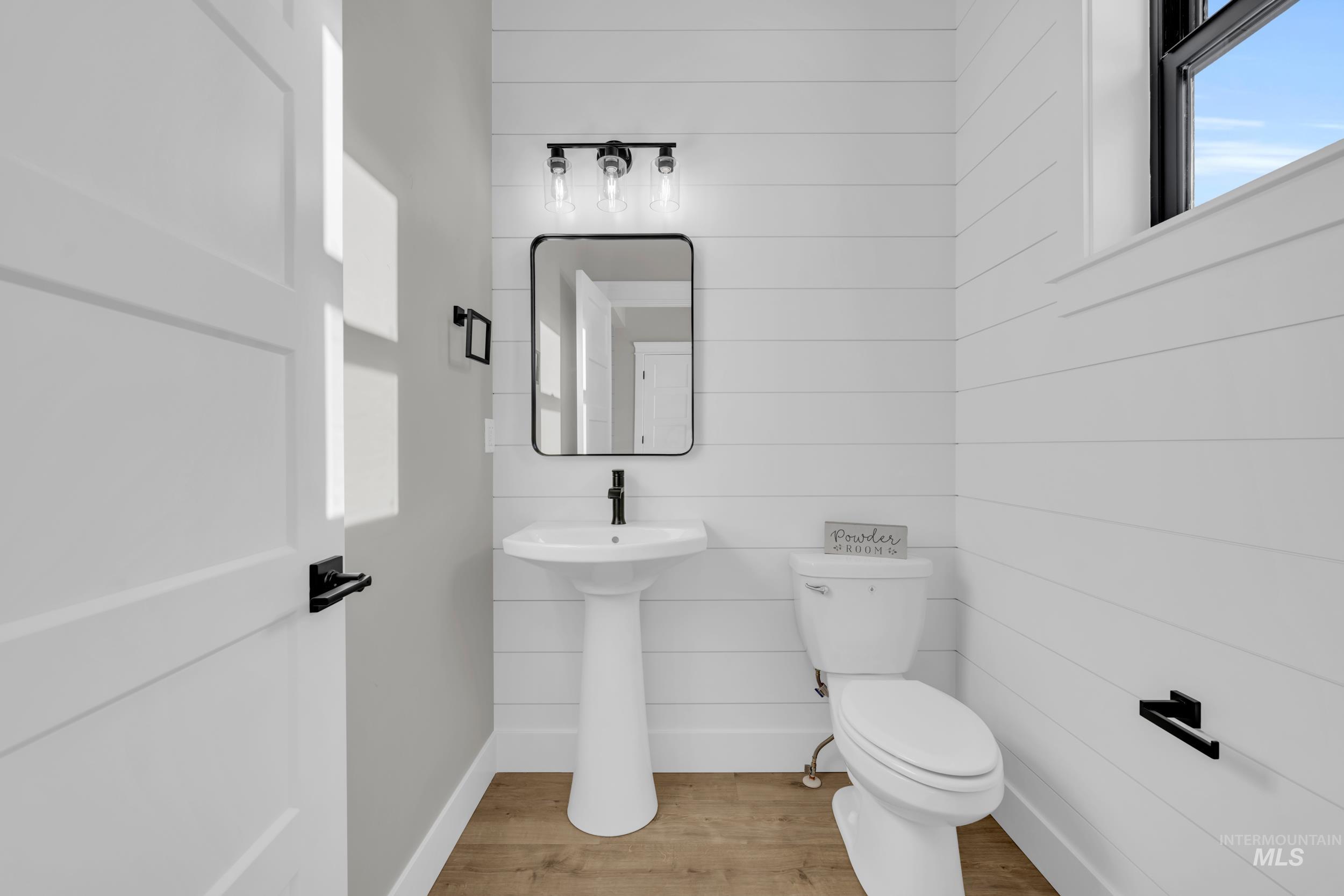 Bathroom featuring wood walls and wood finished floors