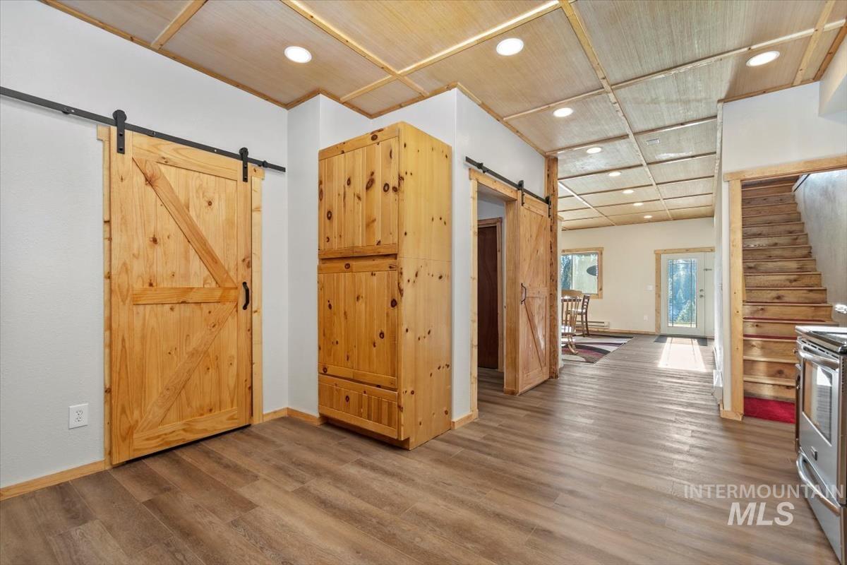 Foyer with recessed lighting, stairway, a barn door, wood finished floors, and wooden ceiling