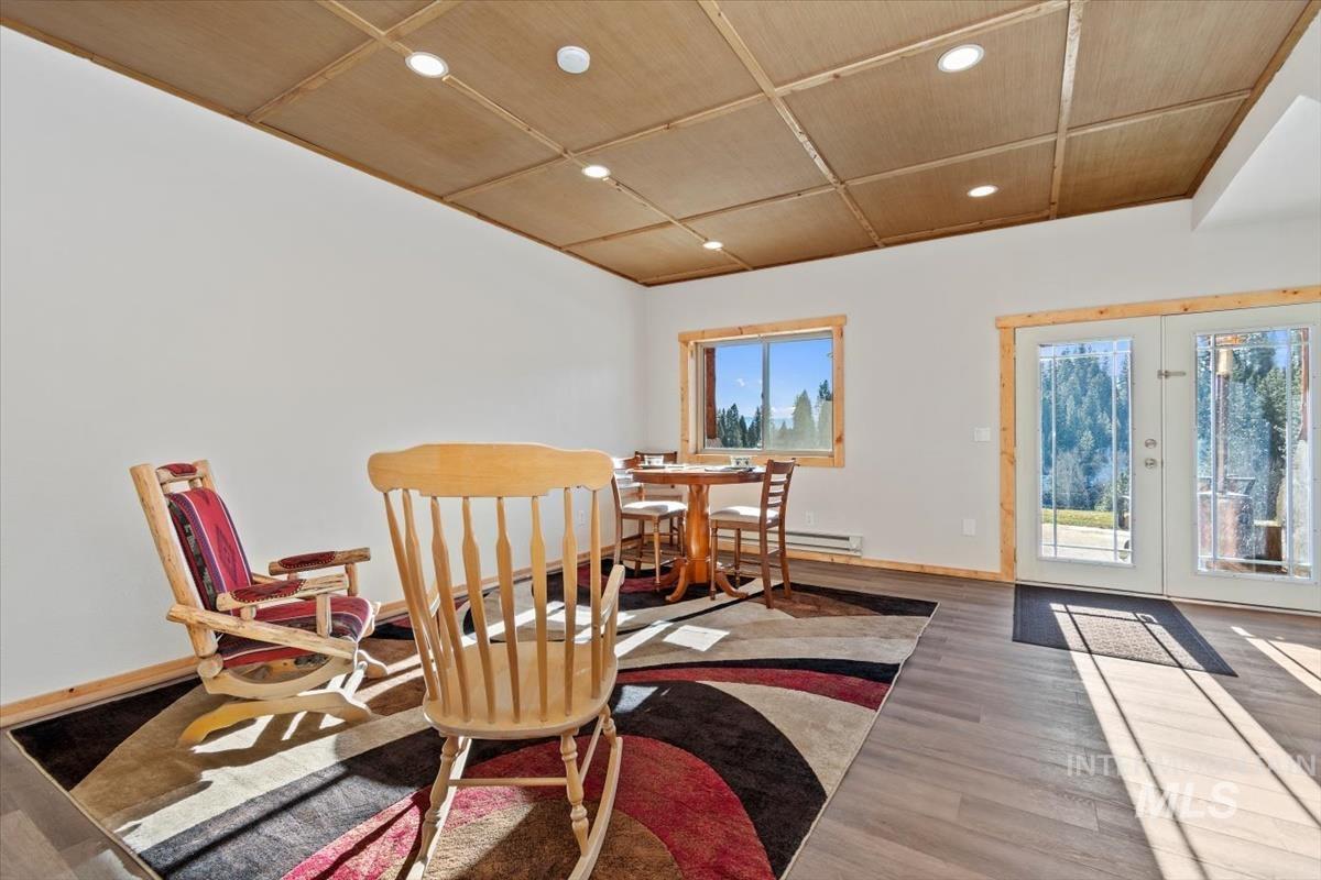 Dining room with healthy amount of natural light, wood finished floors, french doors, recessed lighting, and baseboard heating