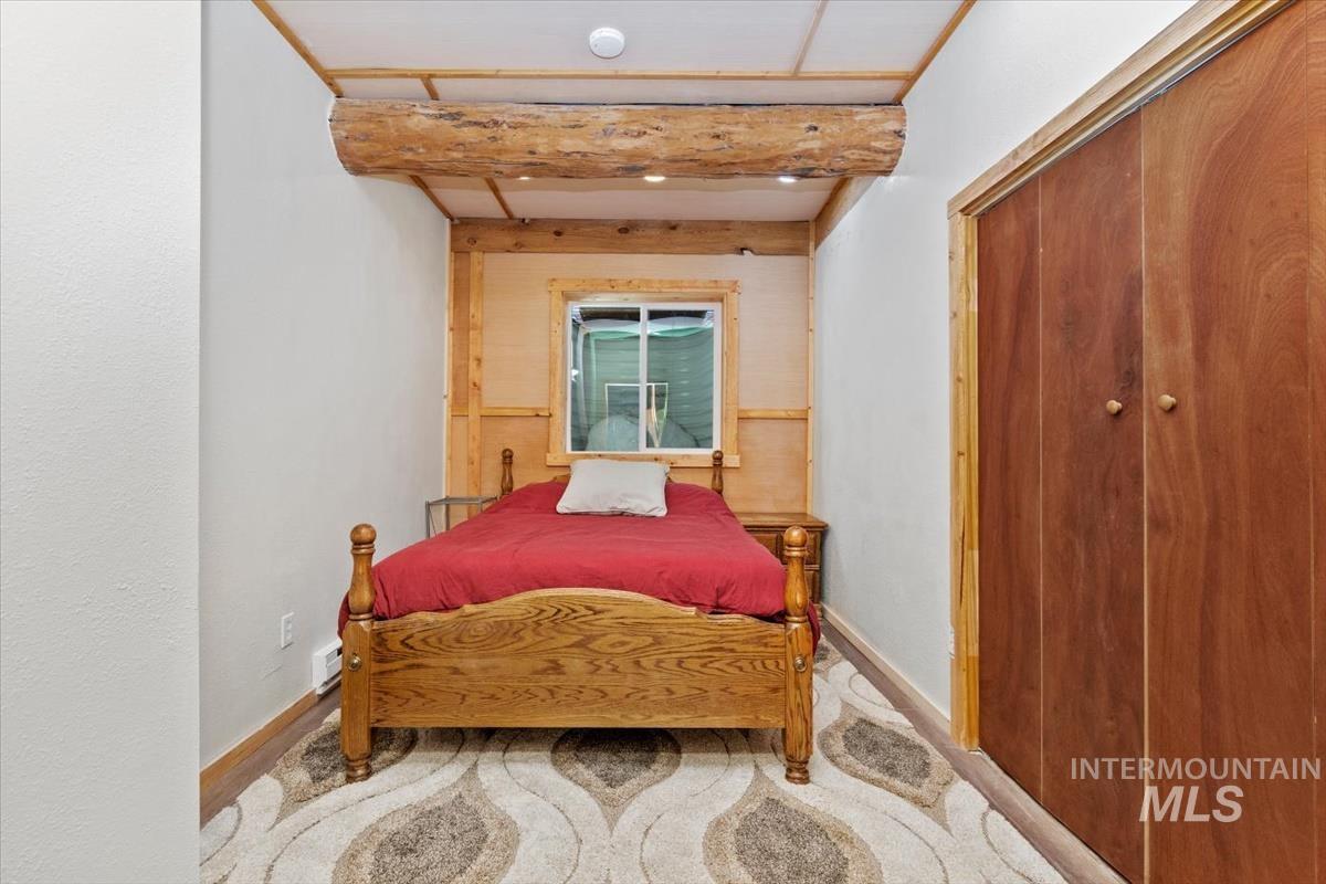 Bedroom with a closet and beamed ceiling