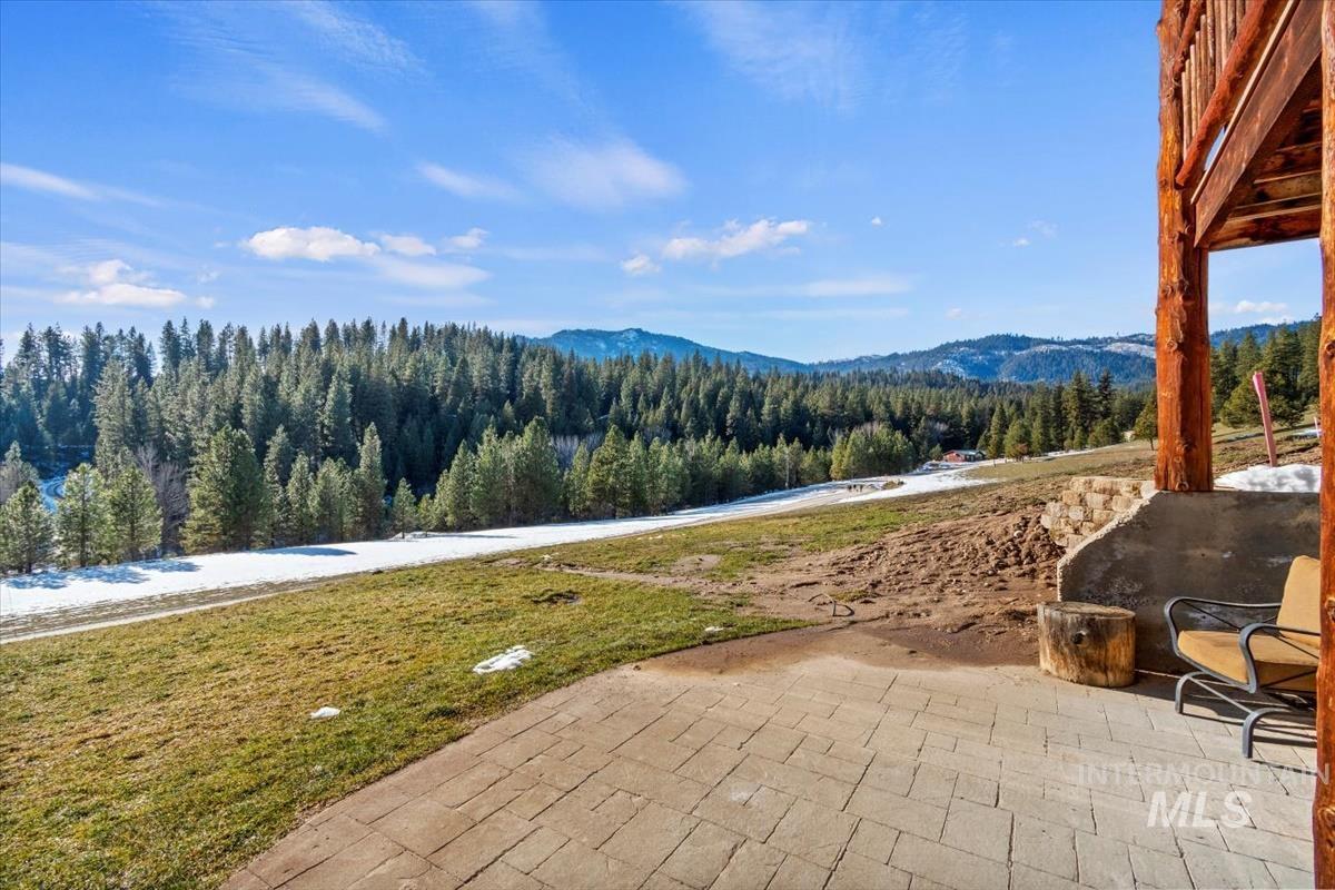 View of patio / terrace with a wooded view and a mountain view