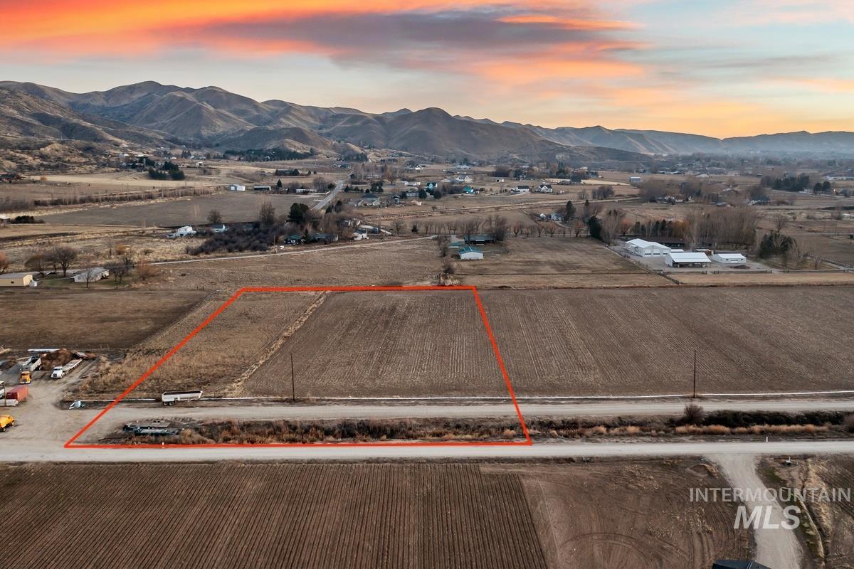 Aerial view at dusk of property parcel outlined, a mountain view, and a view of rural / pastoral area