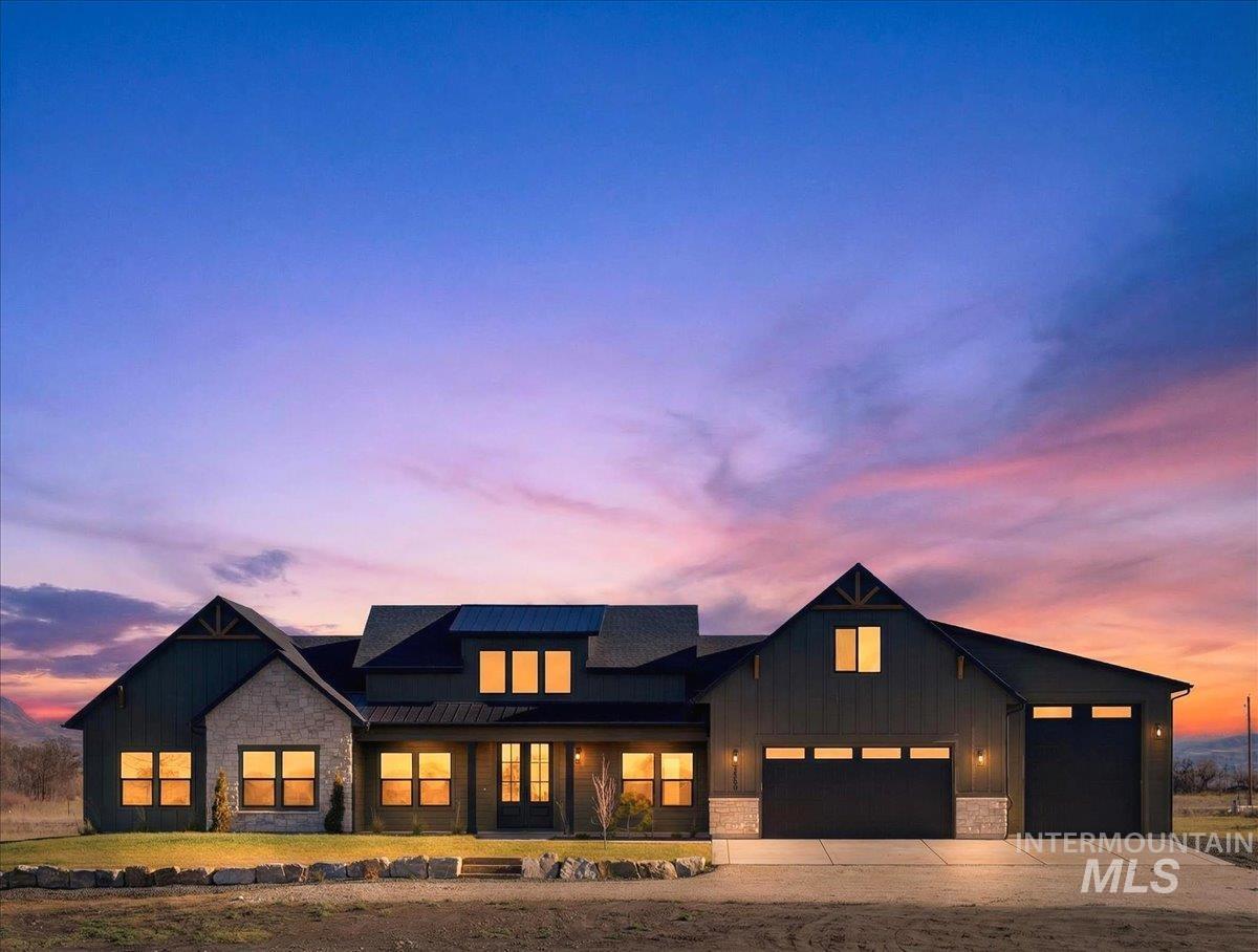 Modern inspired farmhouse with stone siding, board and batten siding, driveway, a metal roof, and a porch