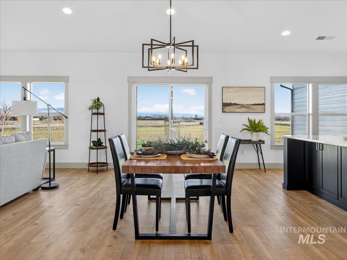 Dining space with light wood-style floors, recessed lighting, plenty of natural light, and a chandelier