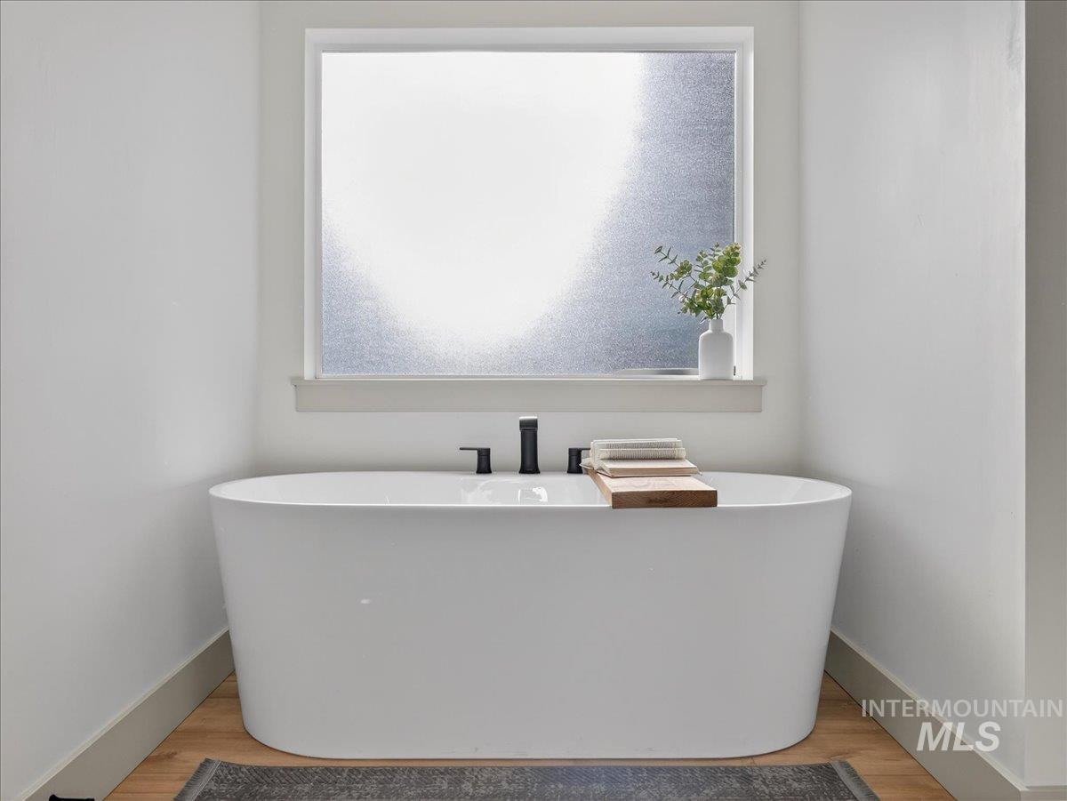 Bathroom featuring a freestanding tub and wood finished floors
