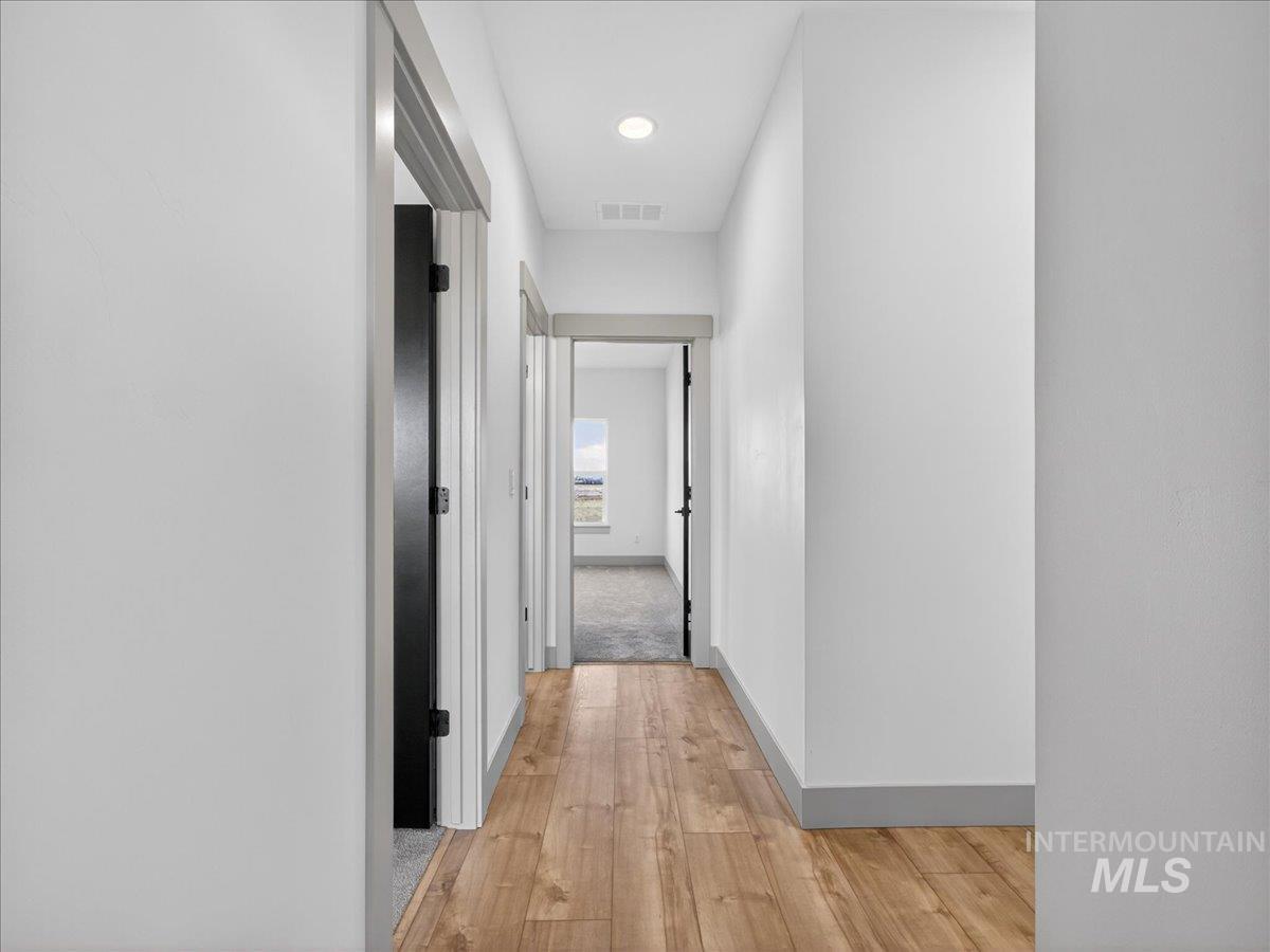 Hall featuring light wood-type flooring and recessed lighting