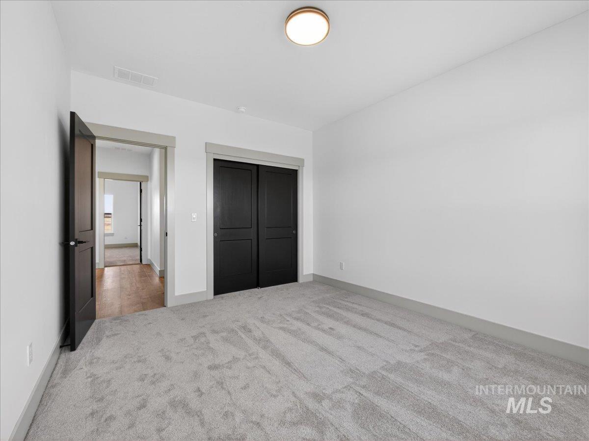 Unfurnished bedroom featuring light colored carpet and a closet