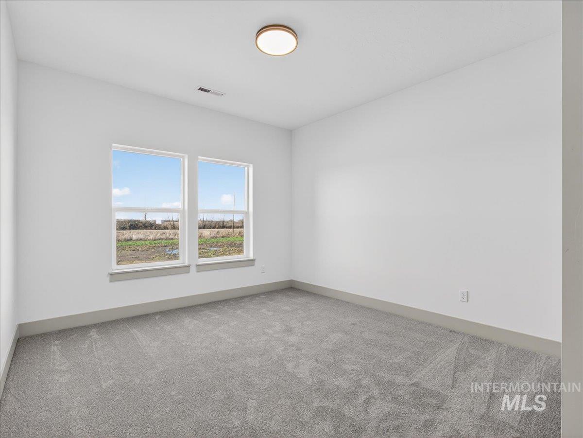 Carpeted spare room with baseboards