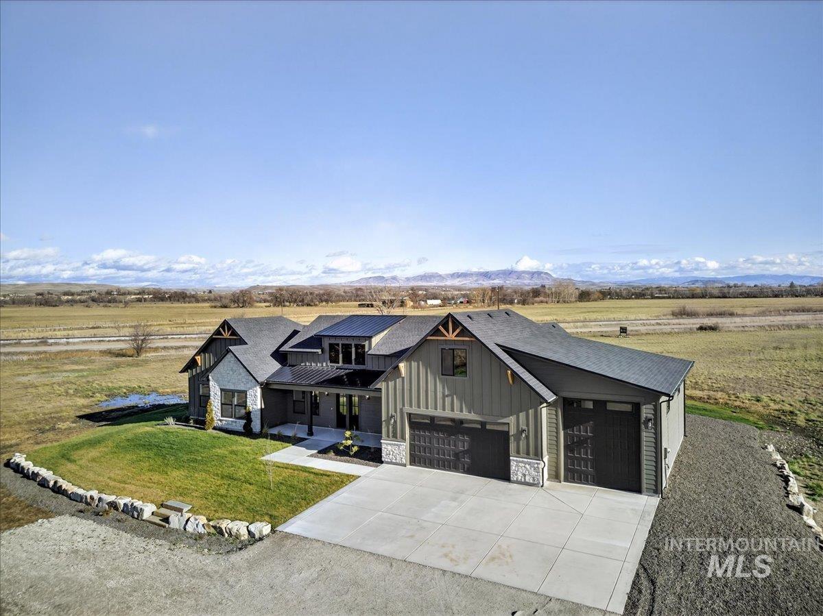 Modern farmhouse with a porch, board and batten siding, stone siding, and driveway