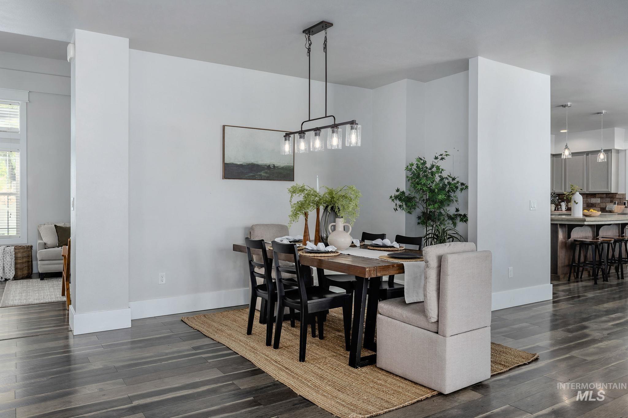 Dining area featuring dark wood-type flooring and baseboards
