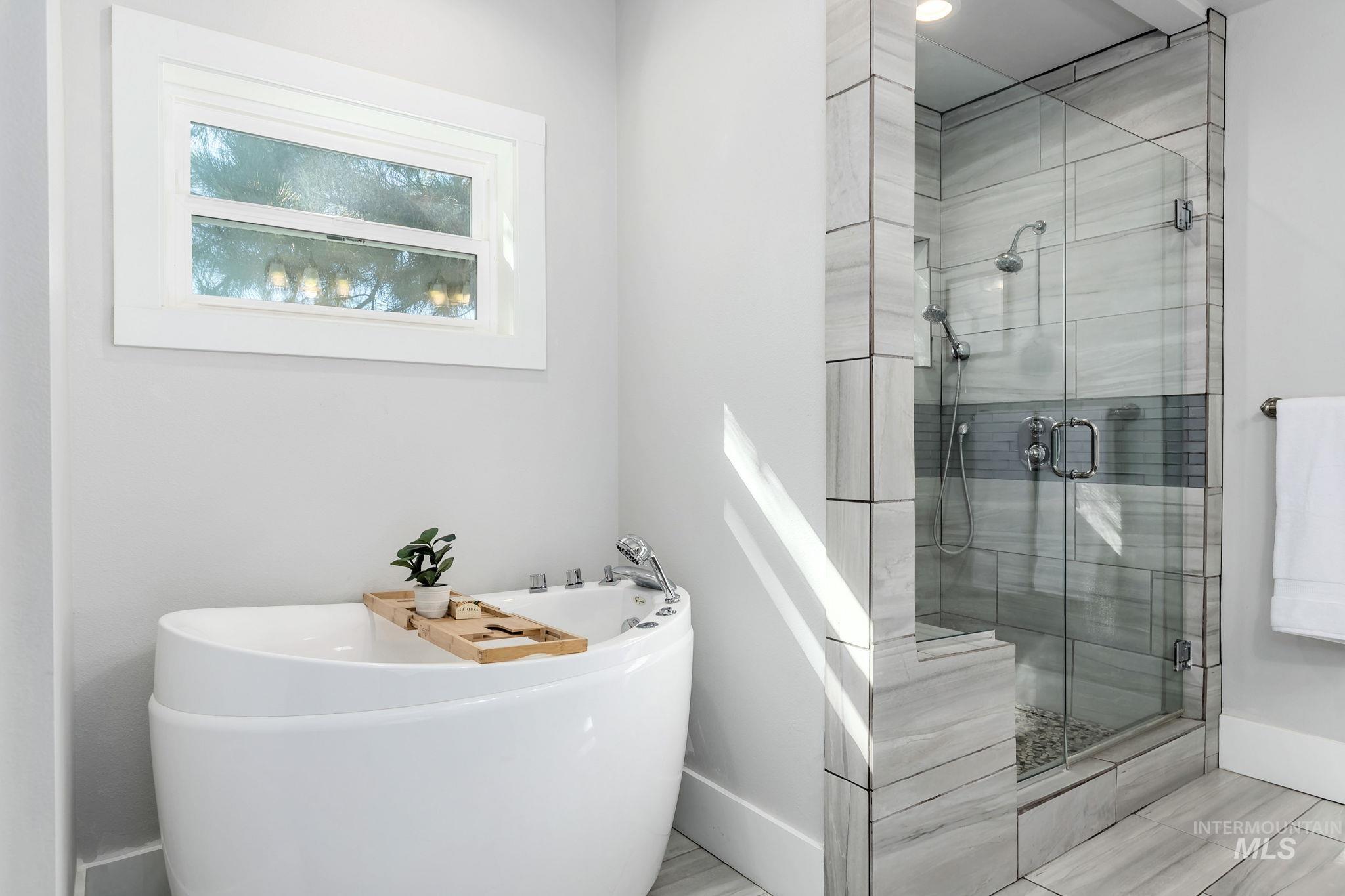 Full bathroom with a soaking tub and a shower stall