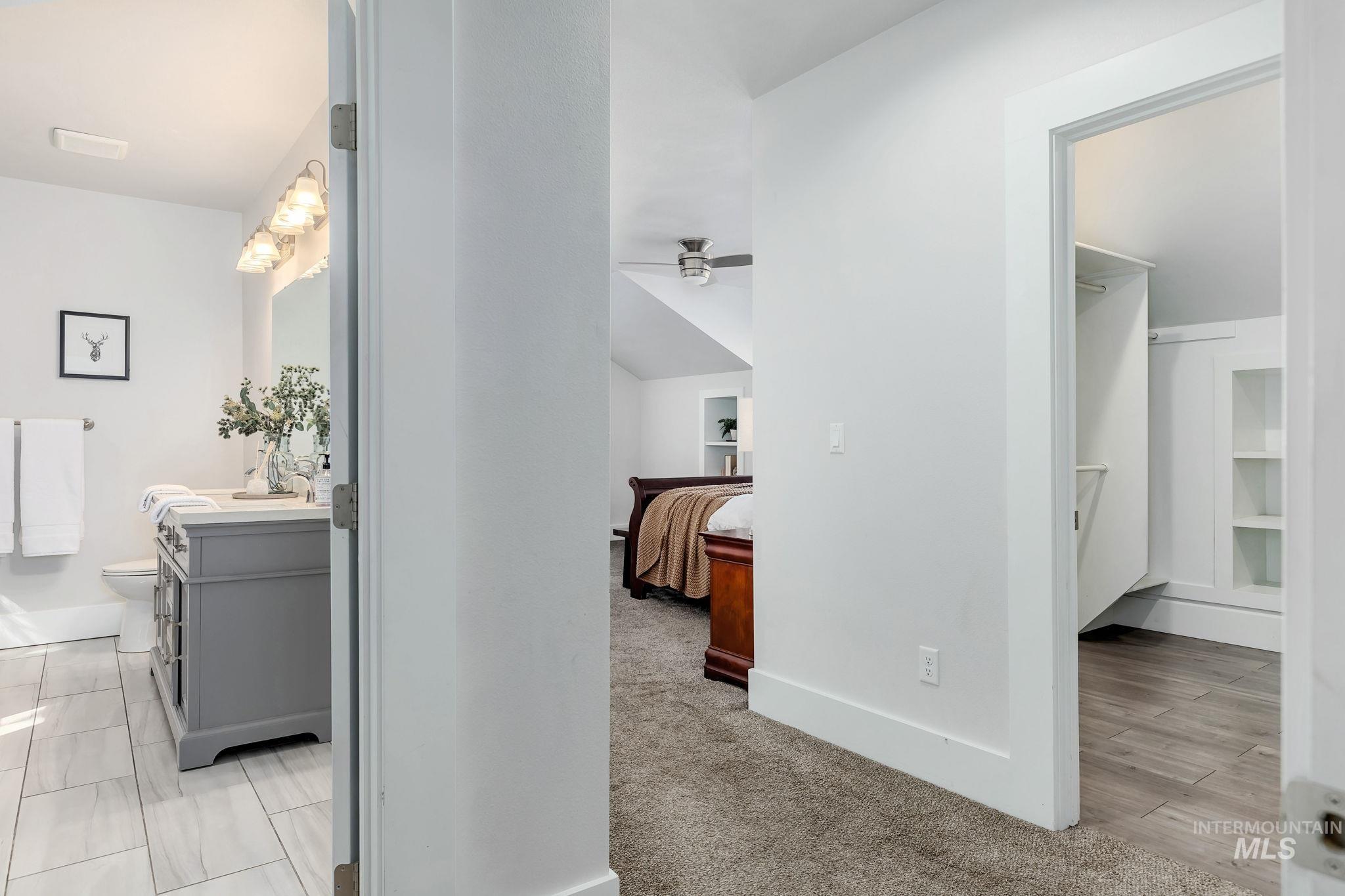 Corridor featuring baseboards and light colored carpet