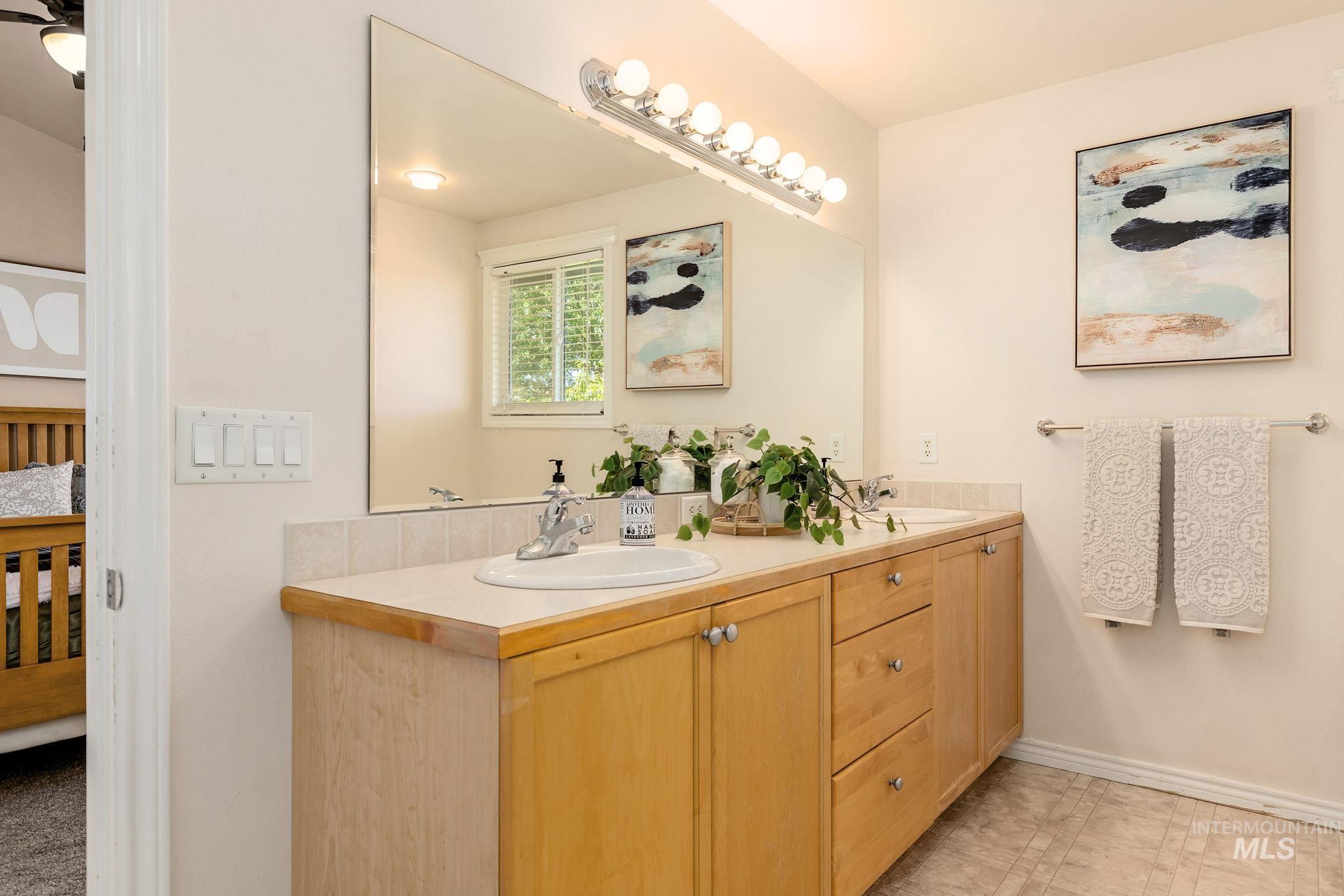 Bathroom with double vanity and baseboards