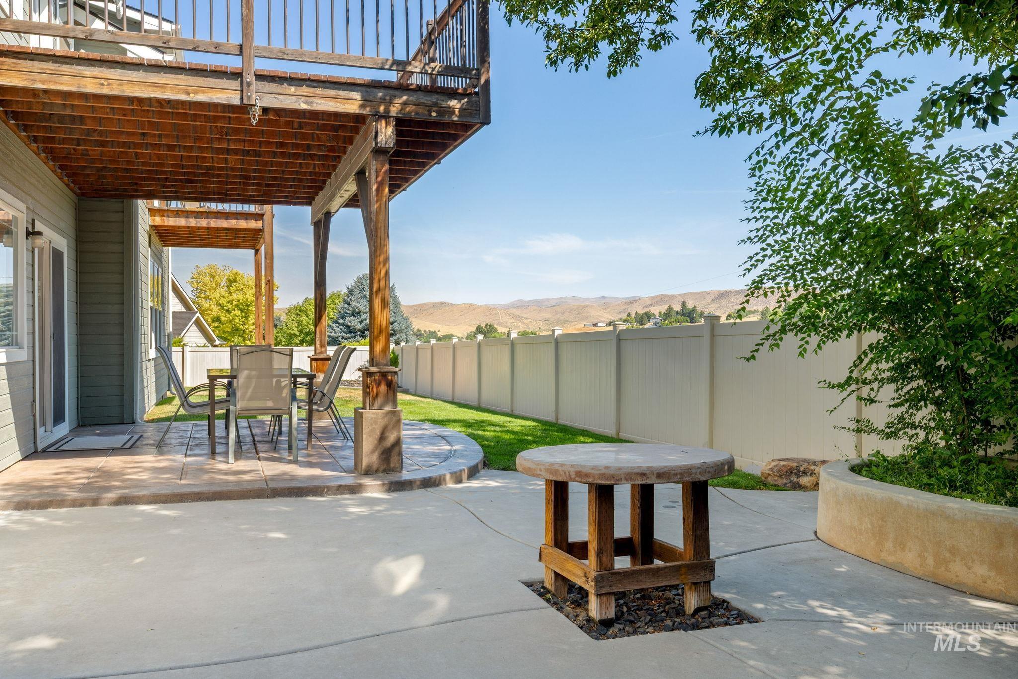 Fenced backyard featuring outdoor dining area, a mountain view, and a patio area