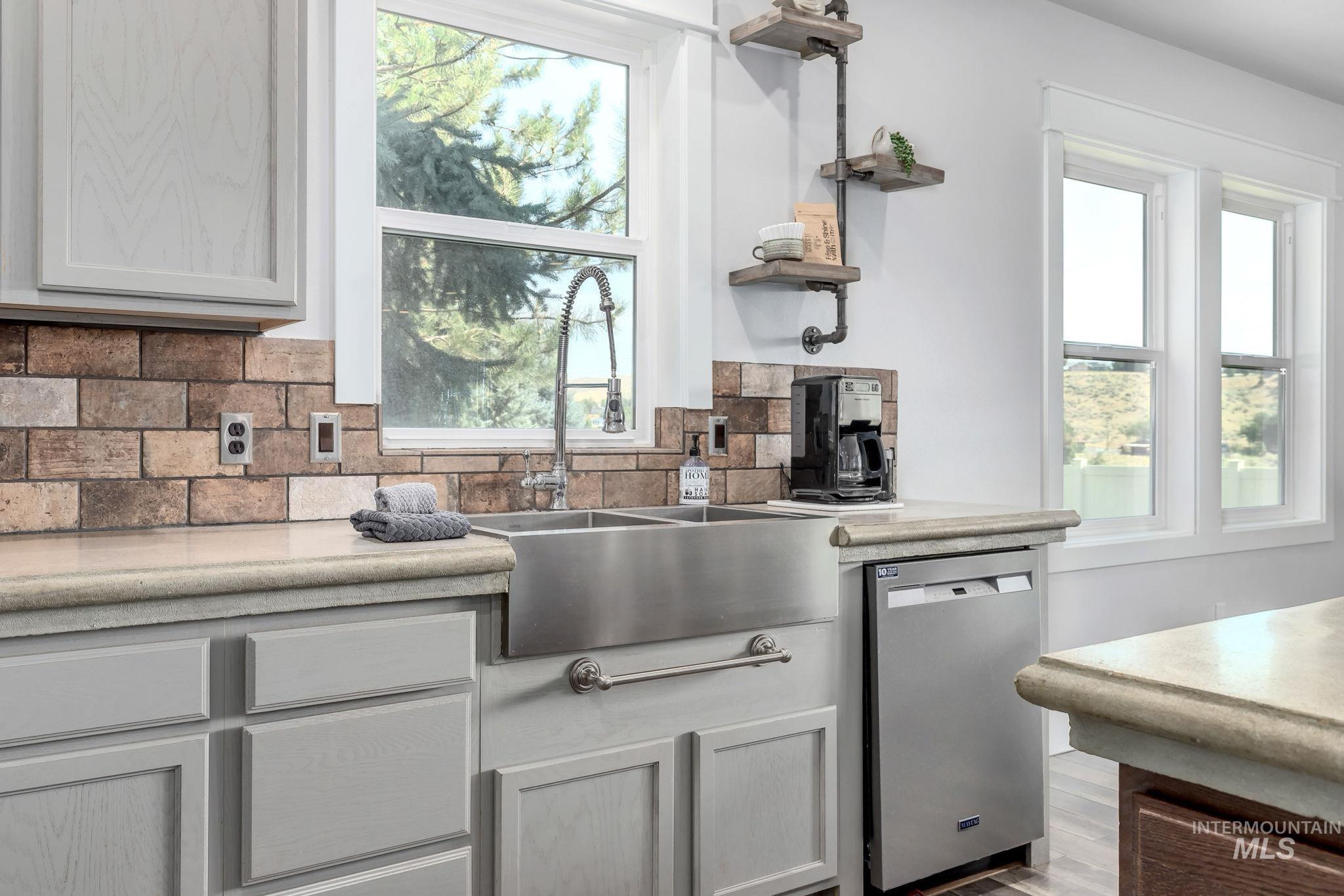 Kitchen featuring backsplash, open shelves, dishwasher, and wood finished floors