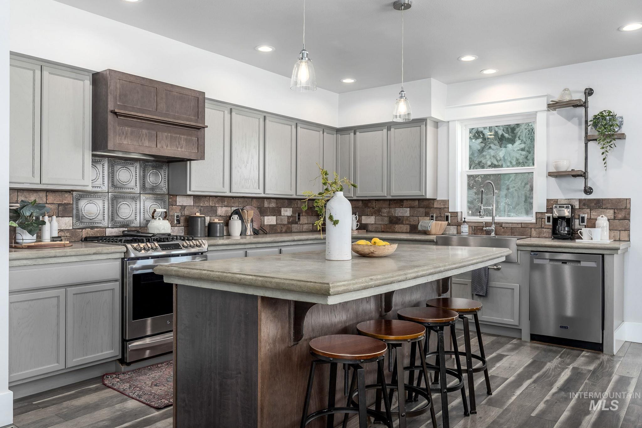 Kitchen featuring decorative backsplash, stainless steel appliances, dark wood finished floors, custom range hood, and recessed lighting