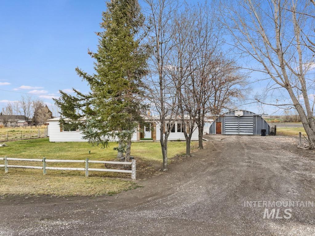 View of front facade with an outbuilding and dirt driveway