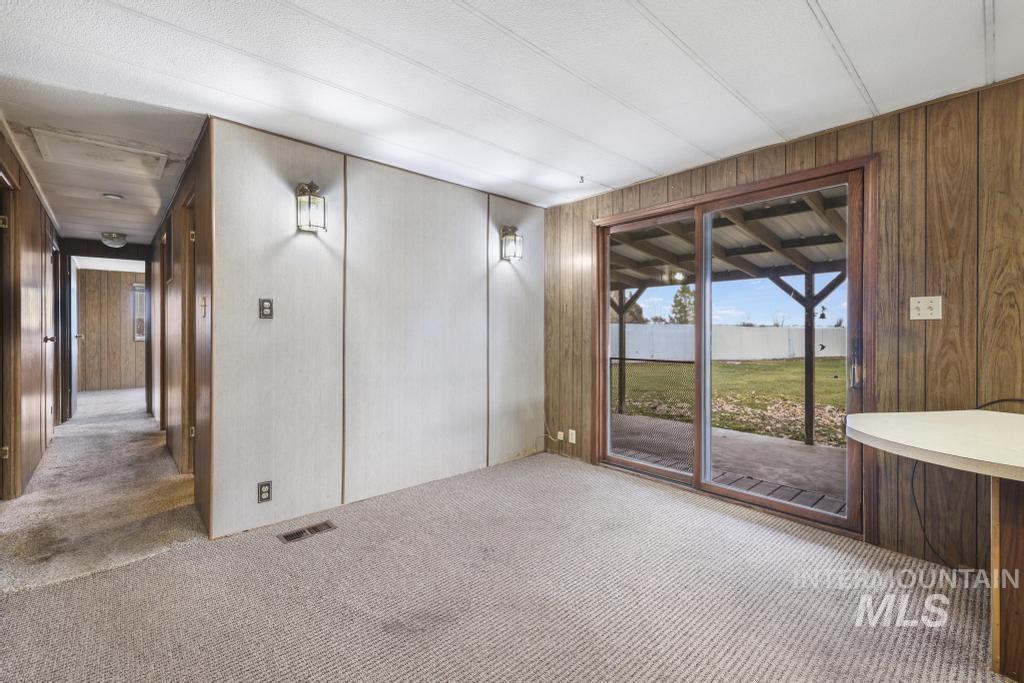 Spare room featuring carpet and wood walls