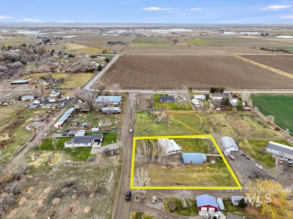 Aerial view of sparsely populated area with property parcel outlined and large plots for crops