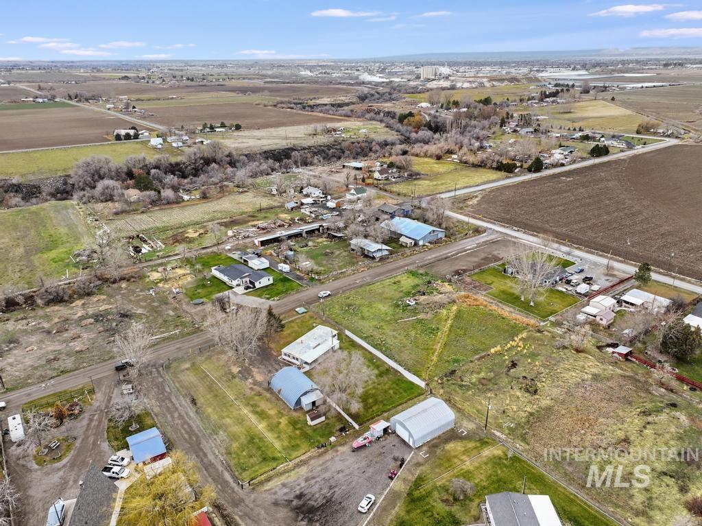 Aerial view of property and surrounding area featuring rural landscape and farmland