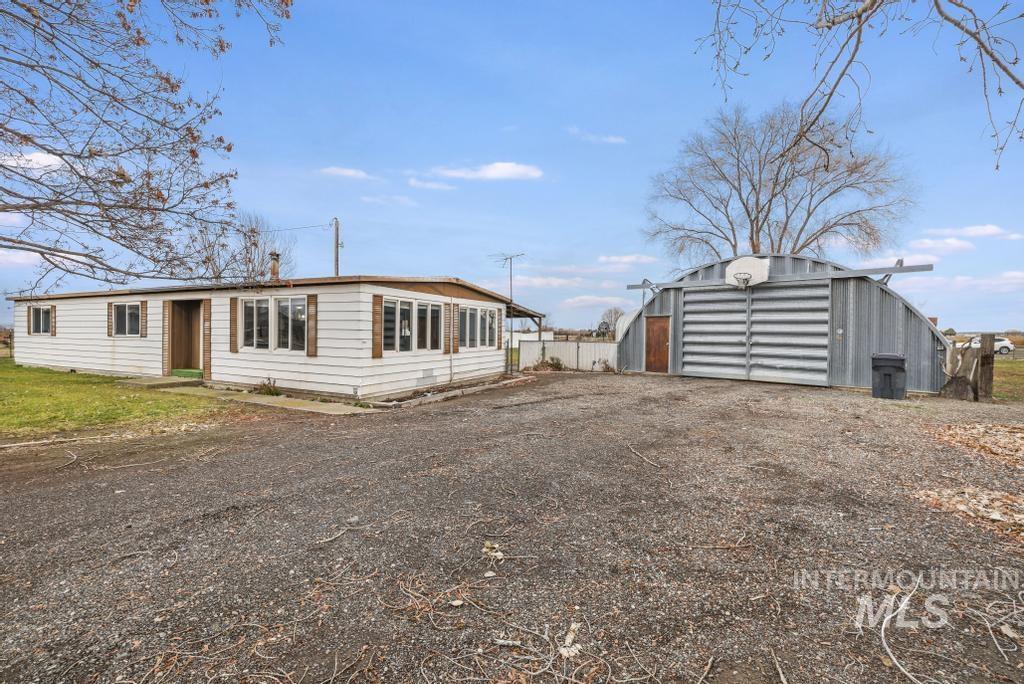 View of front of home with an outbuilding and driveway