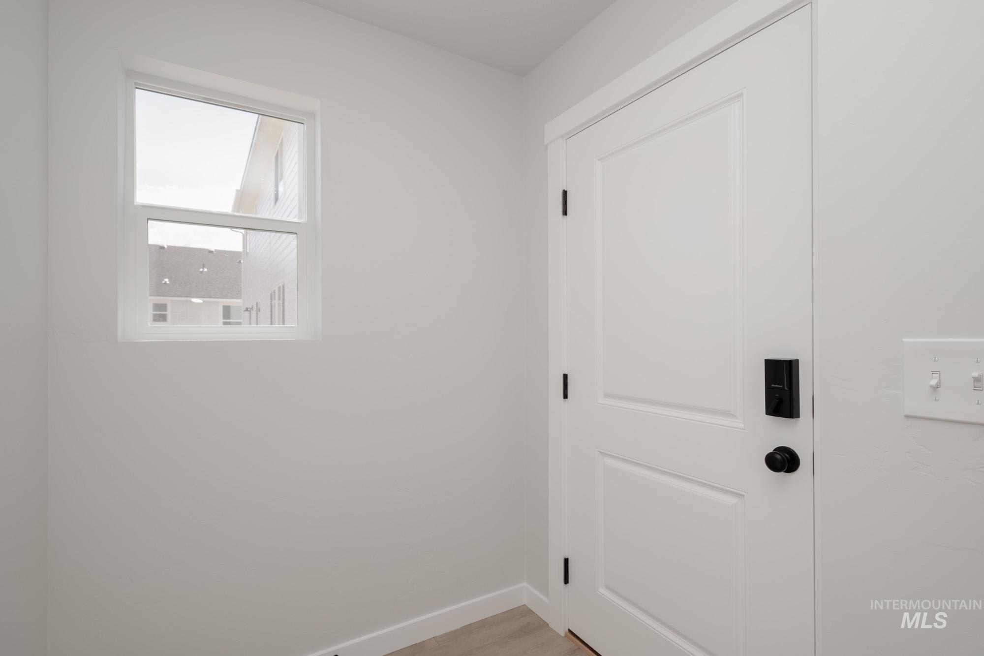 Laundry area with baseboards and light wood-style floors