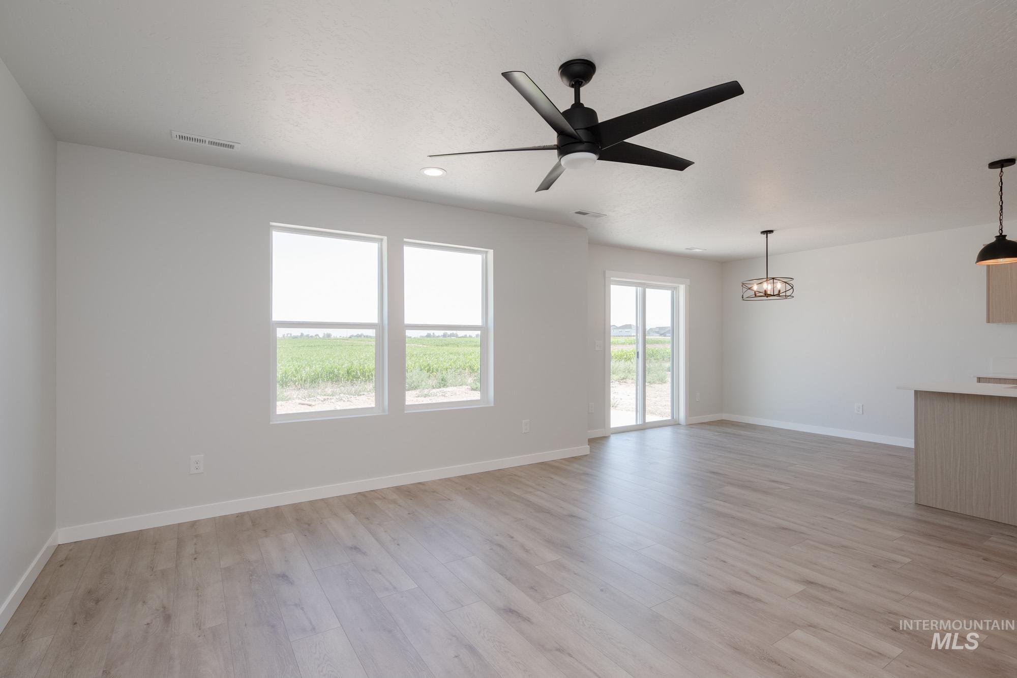 Unfurnished living room featuring a ceiling fan, light wood-style floors, and recessed lighting