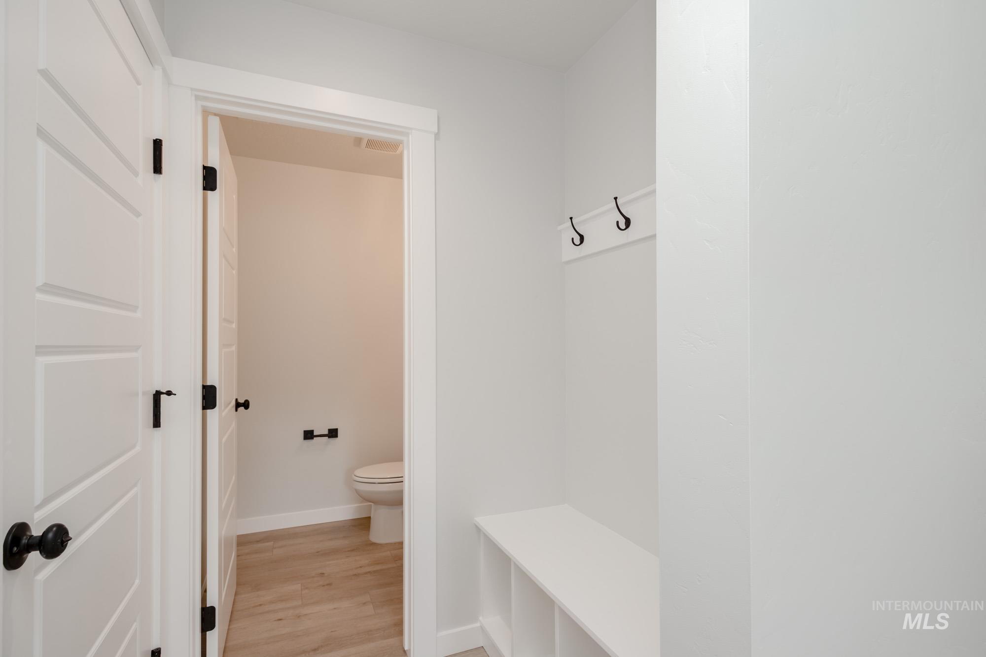 Mudroom featuring light wood-style flooring and baseboards