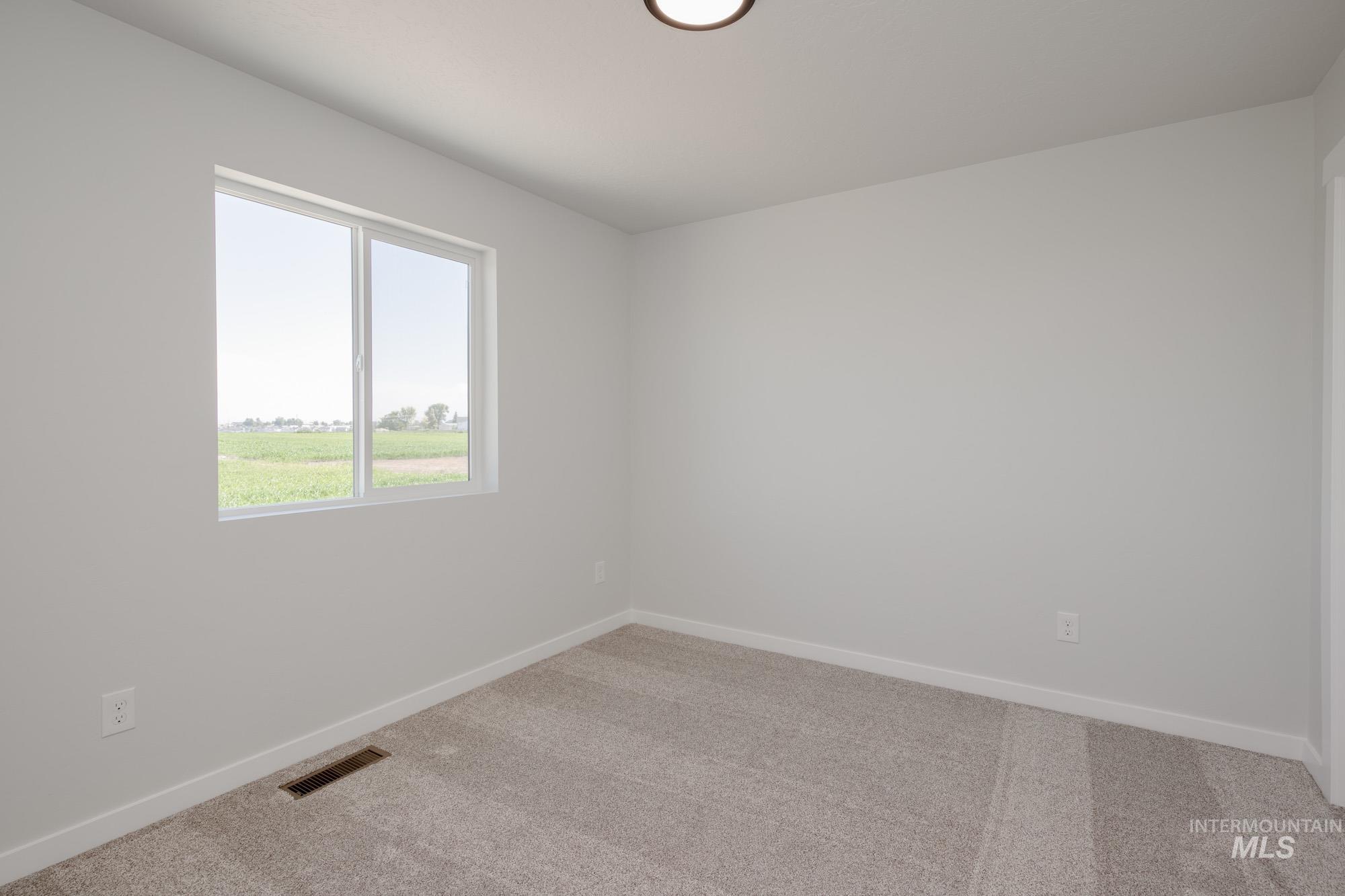 Carpeted empty room with baseboards